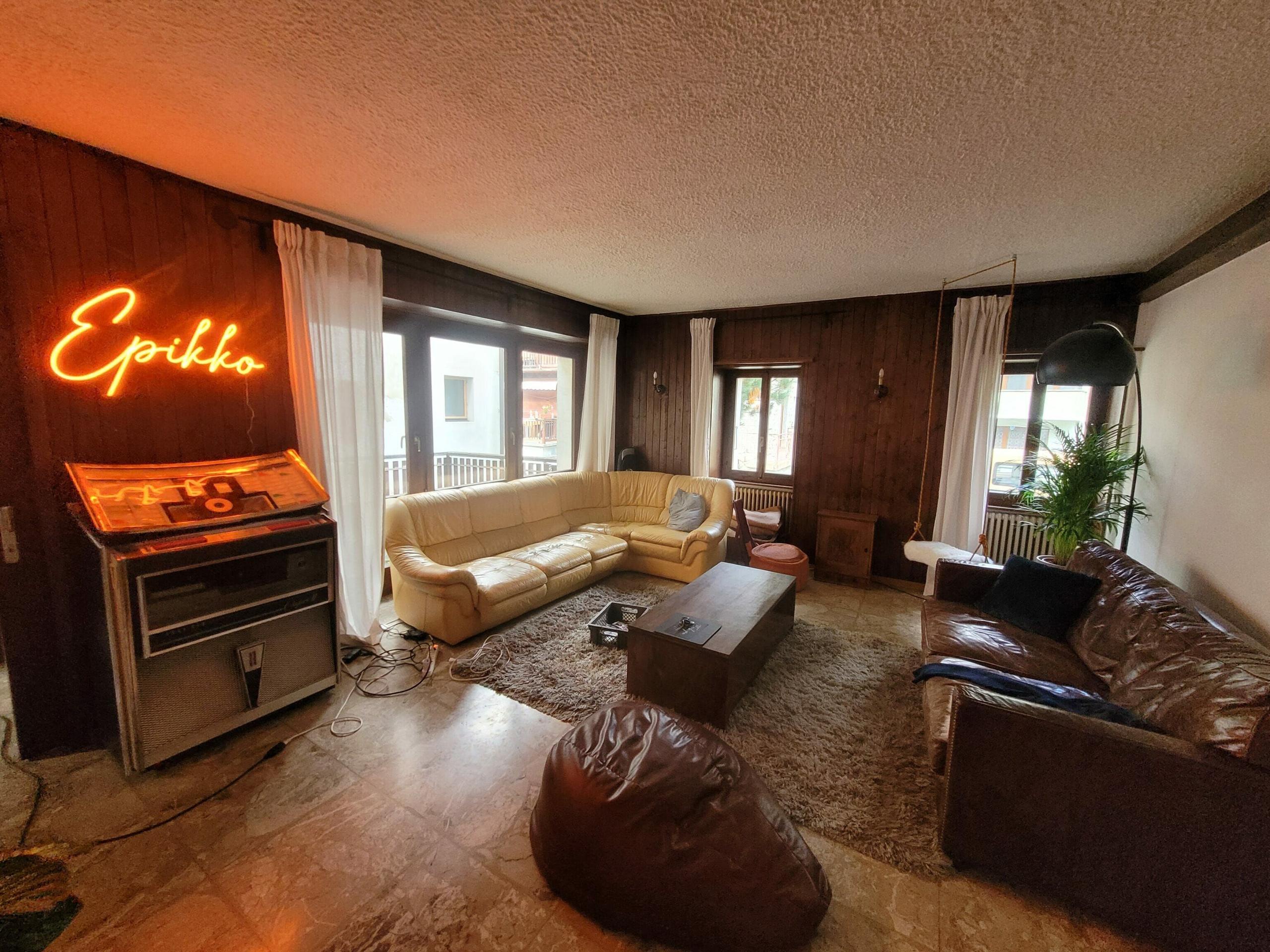 The Alpiness coliving living room, the former restaurant room, featuring sofas and social space.