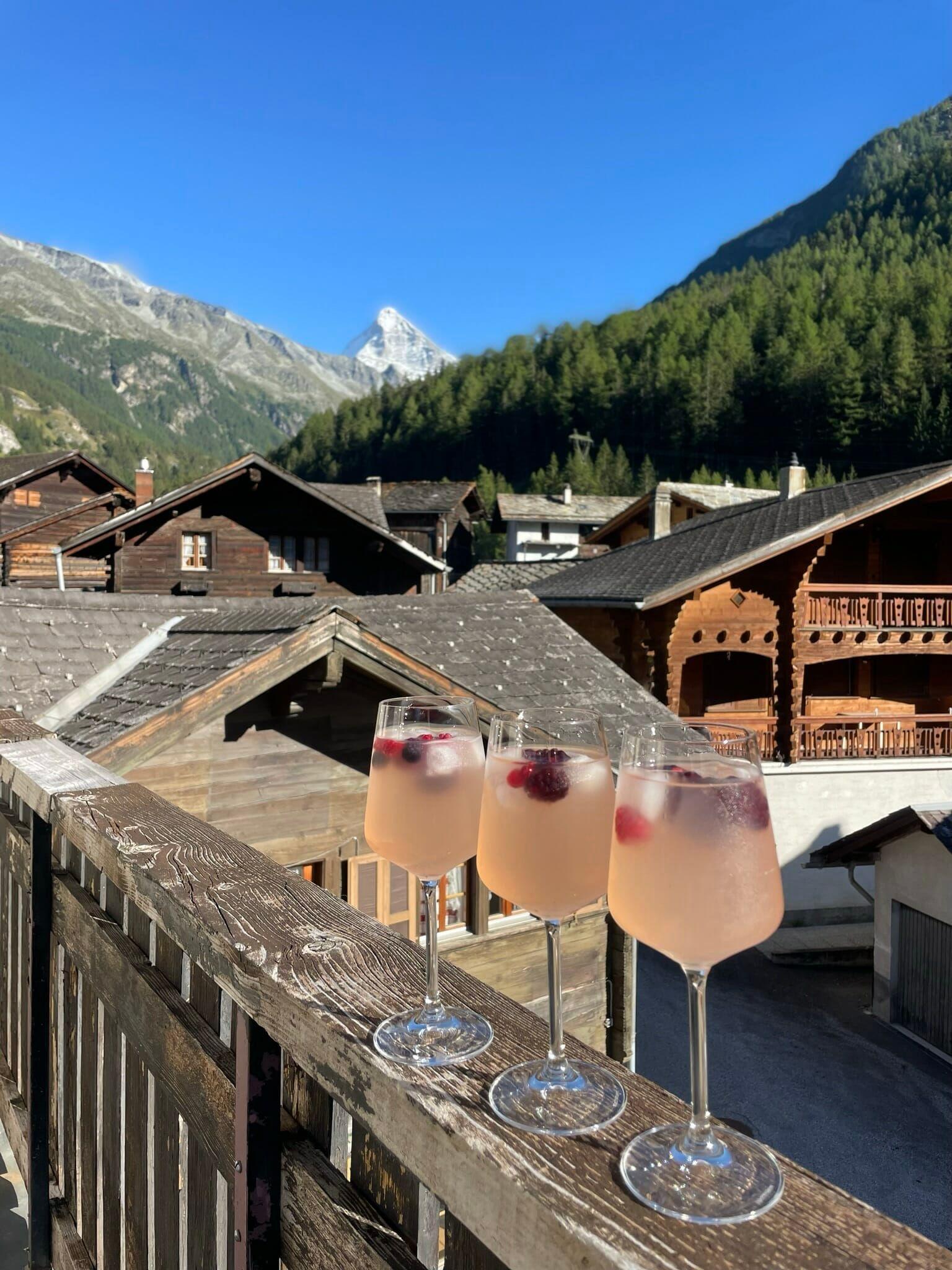 Colivers enjoying an apéro on the Alpiness terrace with a view of the surrounding mountains.