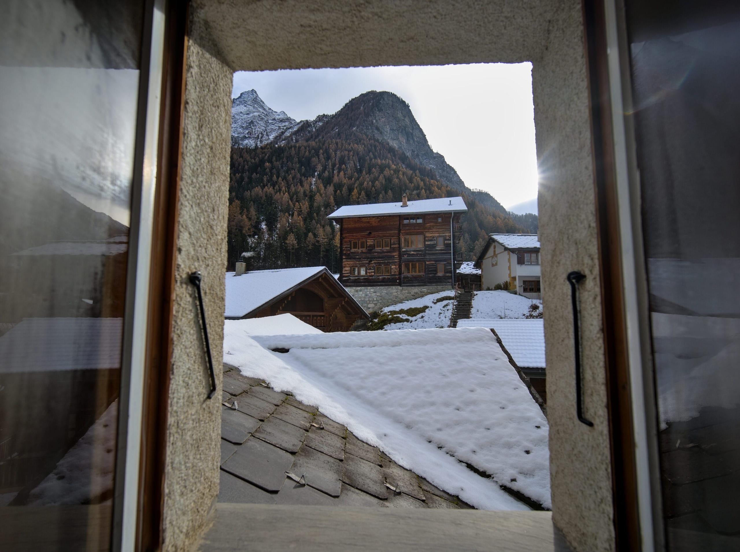 One of the coworking spaces at Alpiness coliving with desks, office chairs, and mountain views.