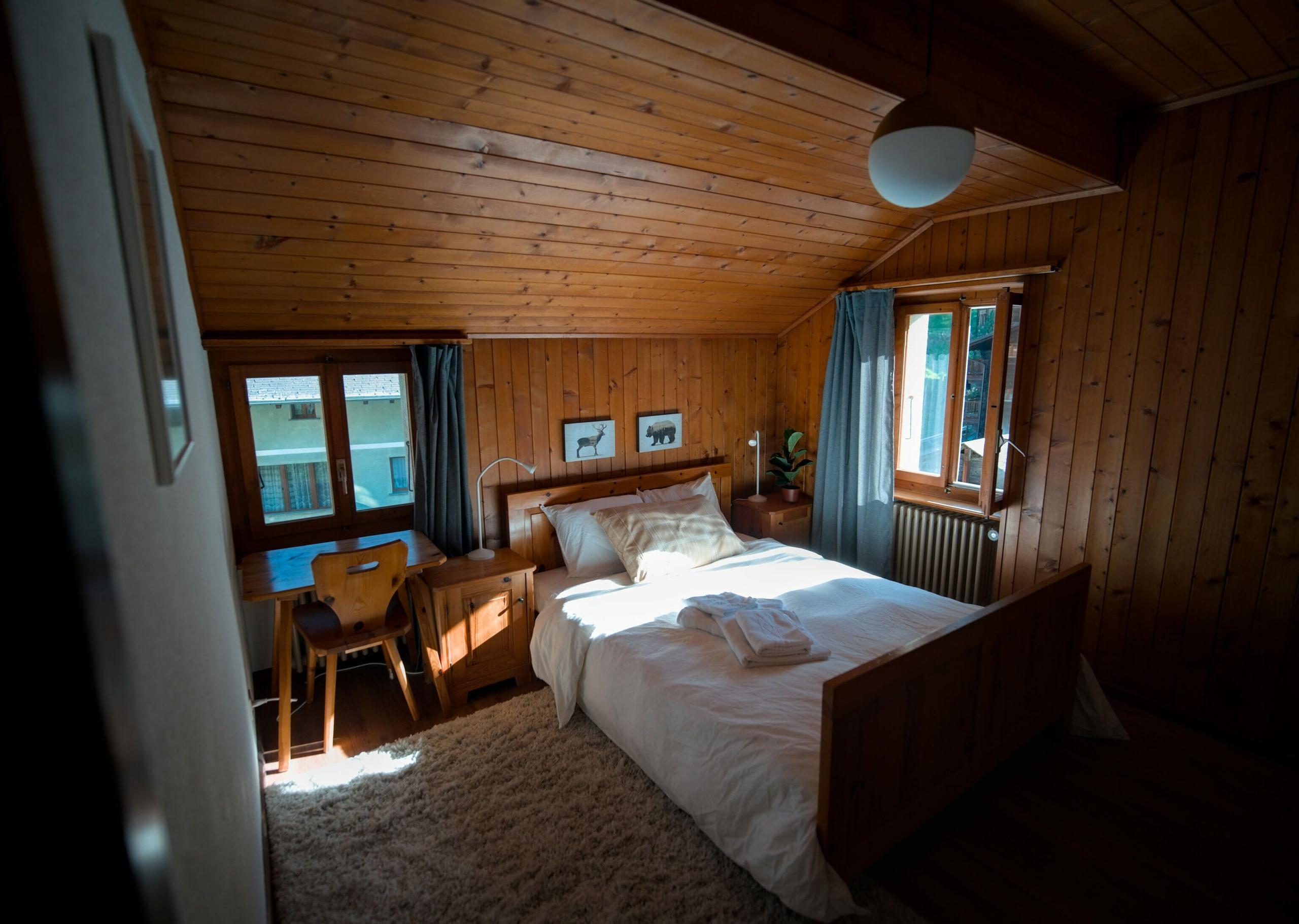 A double bedroom at Alpiness coliving with comfortable bed and mountain view.