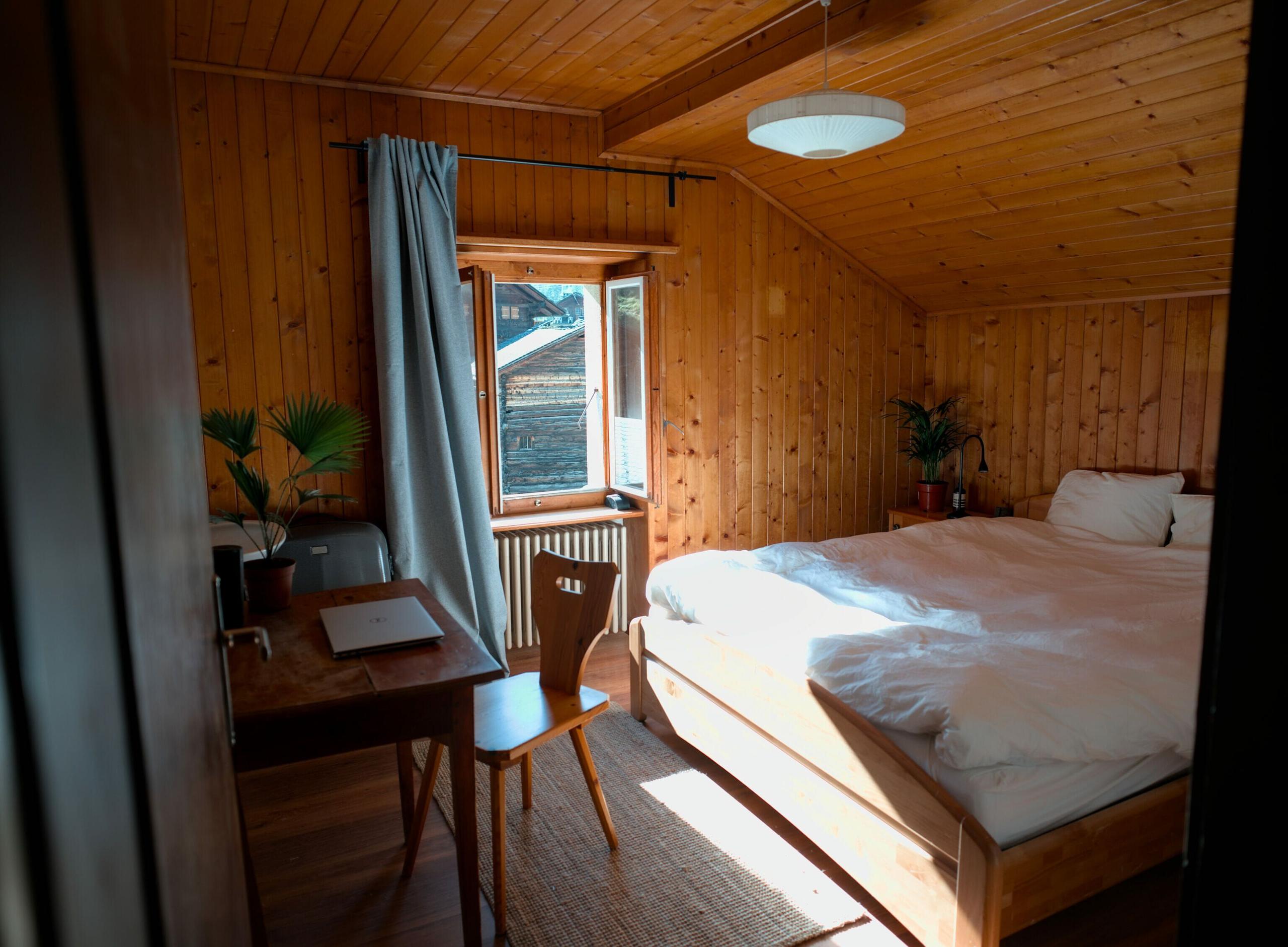 A double room at Alpiness coliving with bed, desk, and wardrobe.