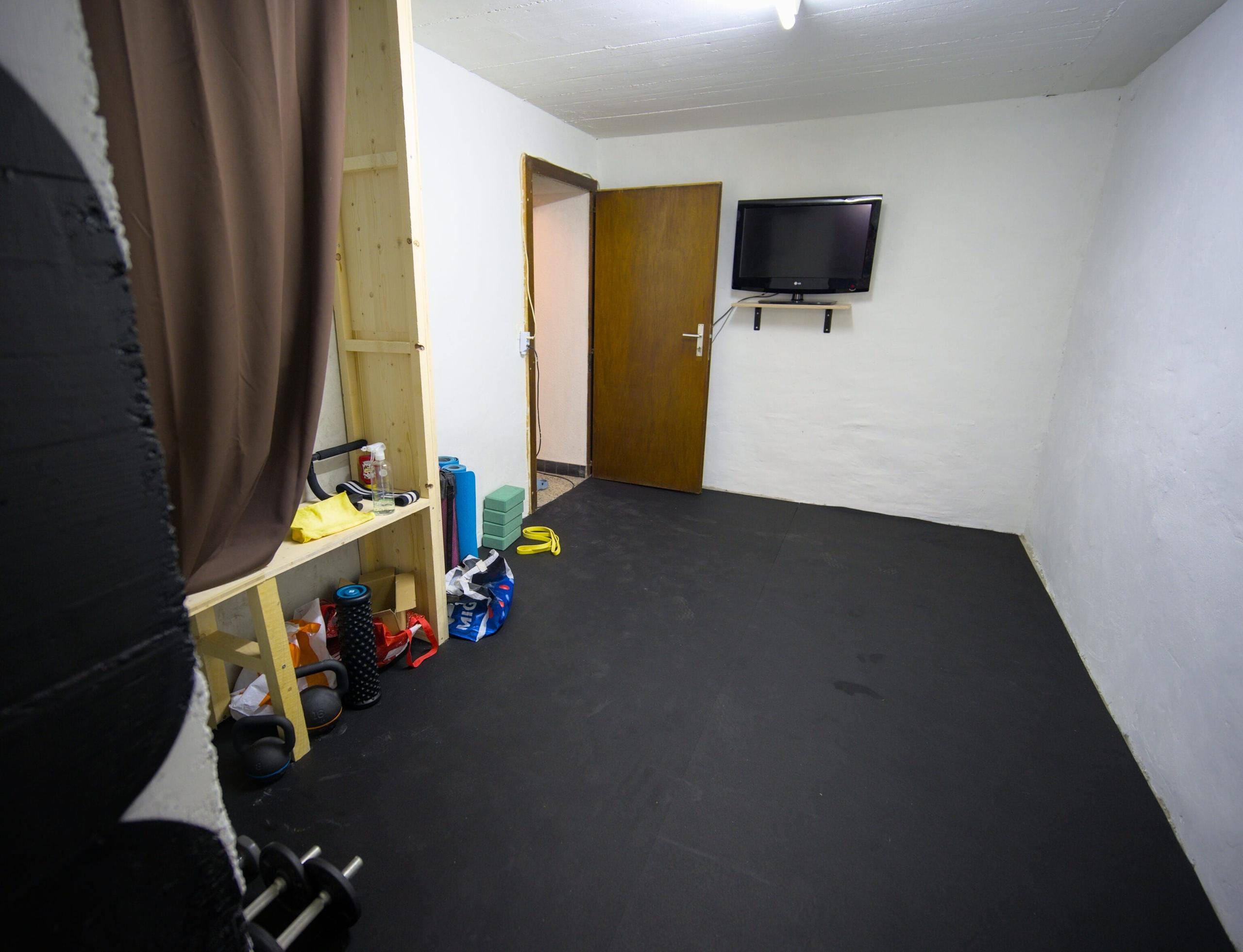 Another view of the Alpiness gym room in the basement, showing the workout space with equipment.