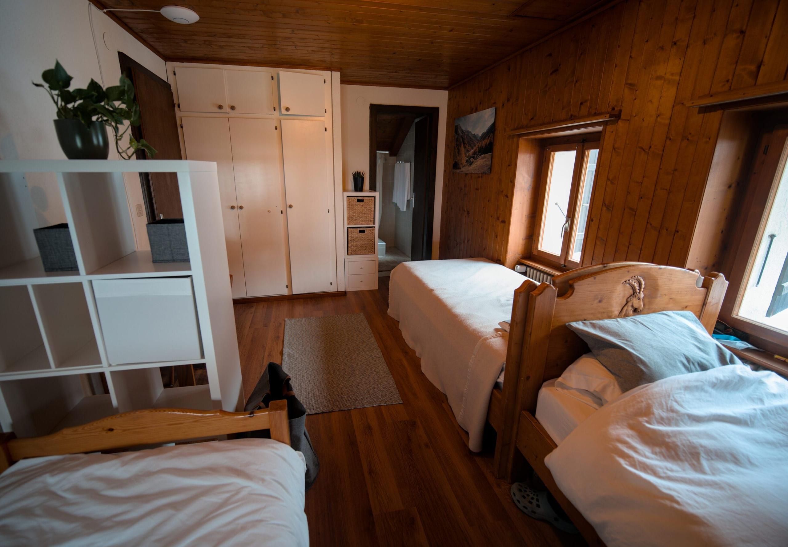 The shared room (3-bed dorm) on the third floor of Alpiness coliving, about 16 sqm with 3 single beds.