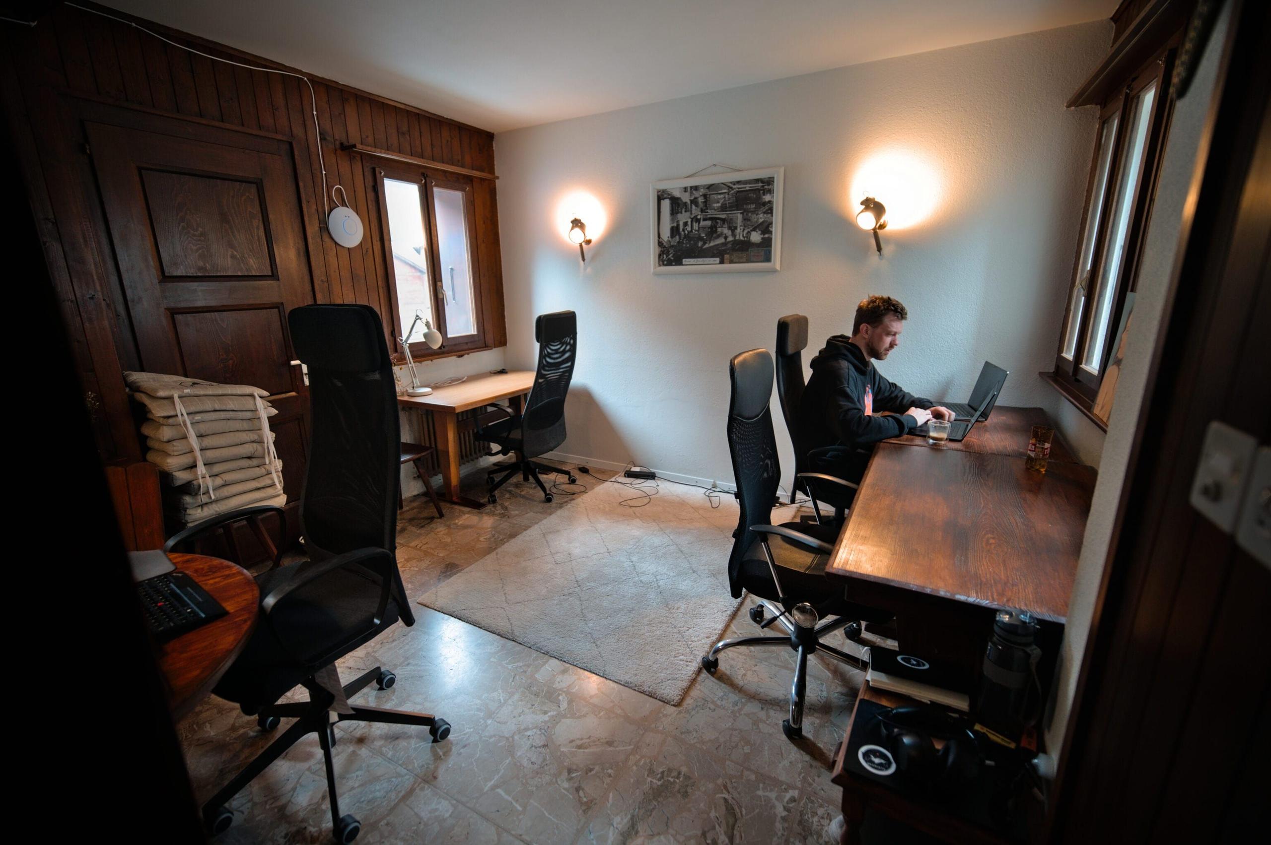 Another view of the social coworking space at Alpiness coliving with working stations and comfortable chairs.