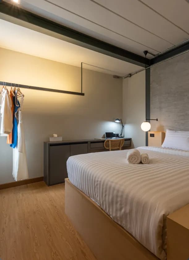 Ensuite room with queen bed, wardrobe rail, desk and lamp