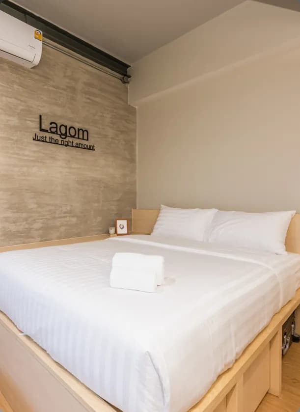 Ensuite Single room with queen bed and 'Lagom – Just the right amount' wall sign