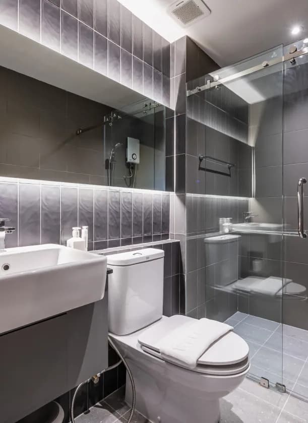 Ensuite Single private bathroom with glass shower, toilet and dark tile