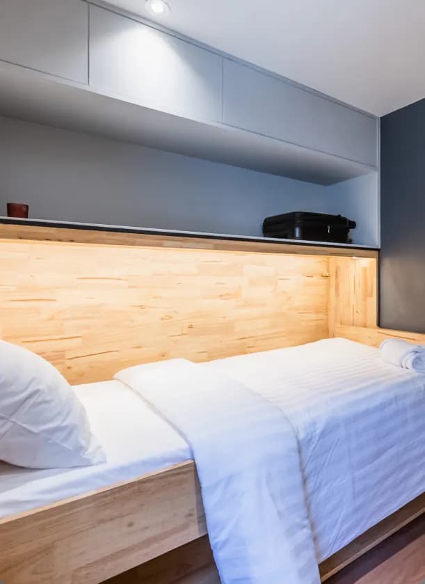 Flexie room with single bed in wooden frame with overhead storage