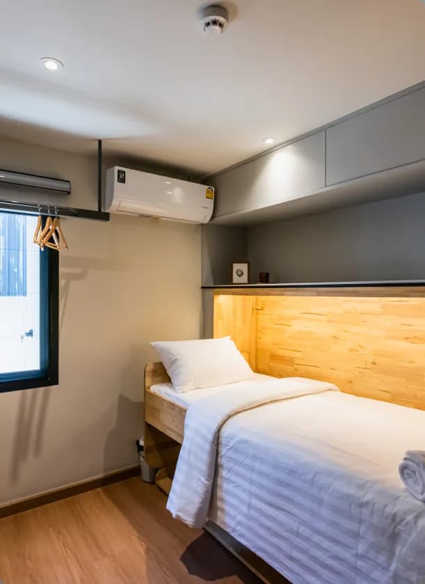 Flexie room with single bed, window, air conditioning and clothes hangers