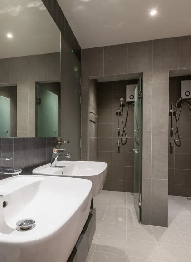 Flexie shared bathroom with double sinks, mirrors and two shower stalls