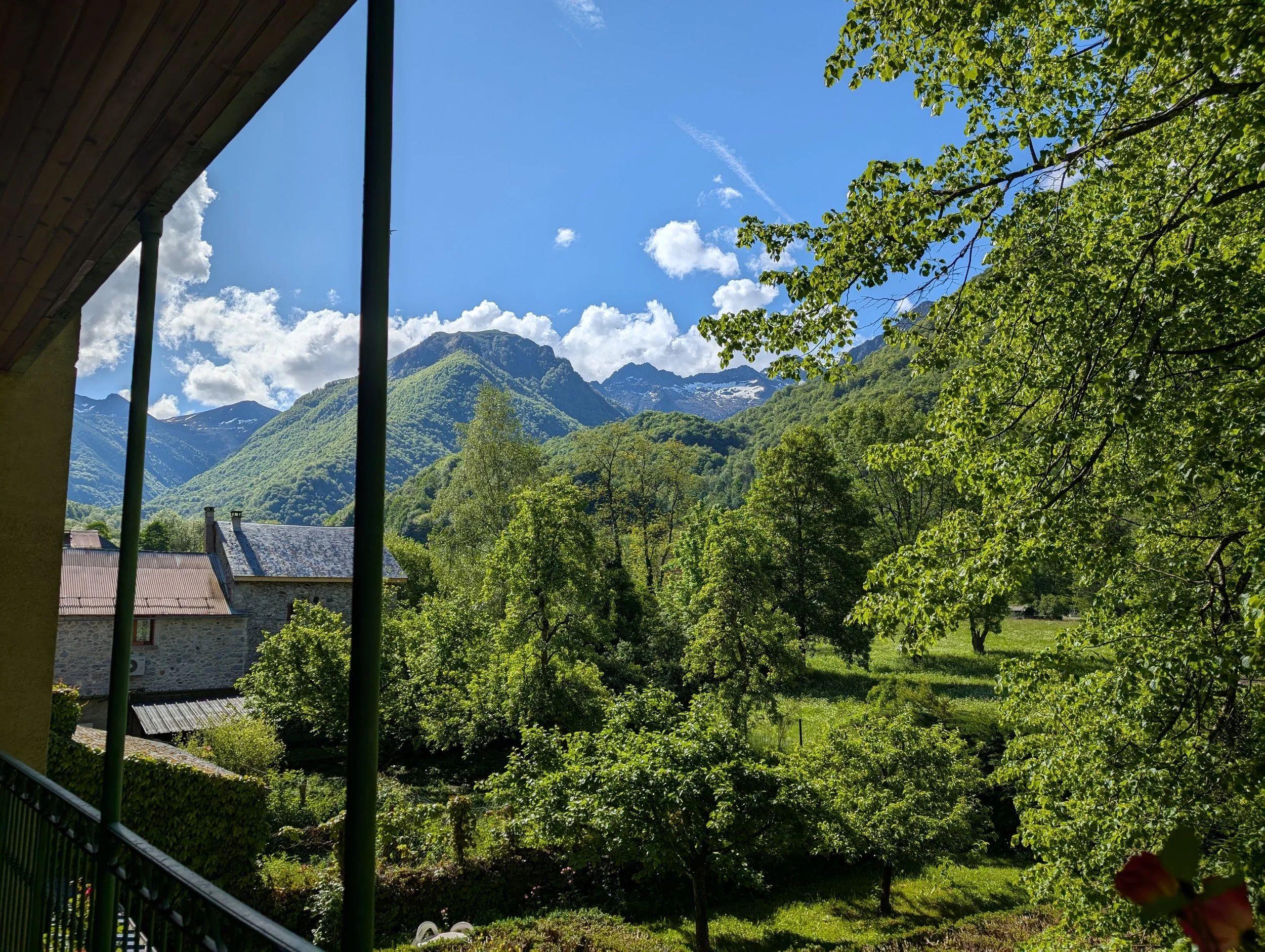 View of the French Pyrenees mountains and surrounding greenery from a balcony or terrace of the coliving