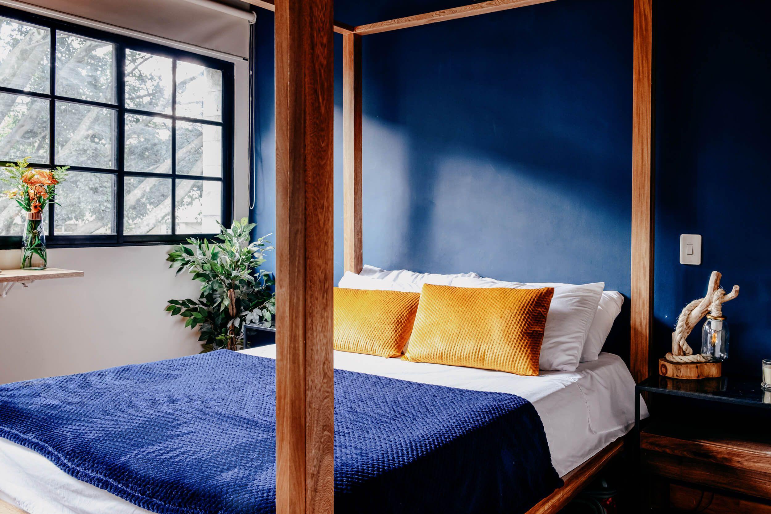 Main view of Bedroom 2 with a four poster bed, lots of natural light, and private balcony access