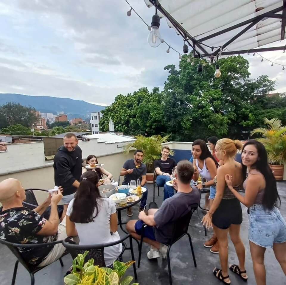 Balu guests enjoying a shared dinner on the rooftop terrace with string lights and mountain views