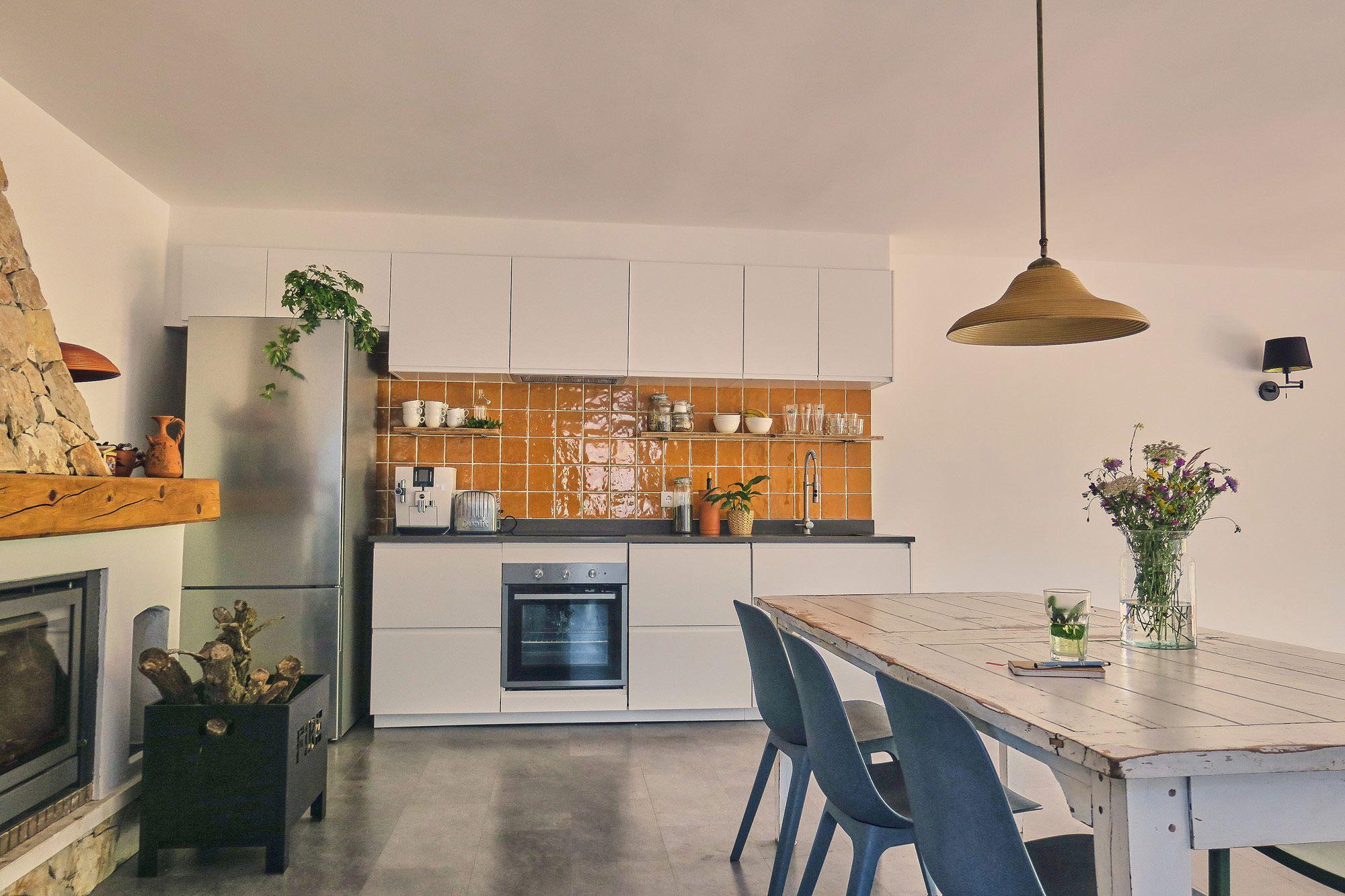 The shared kitchen with dining table in front of the fireplace