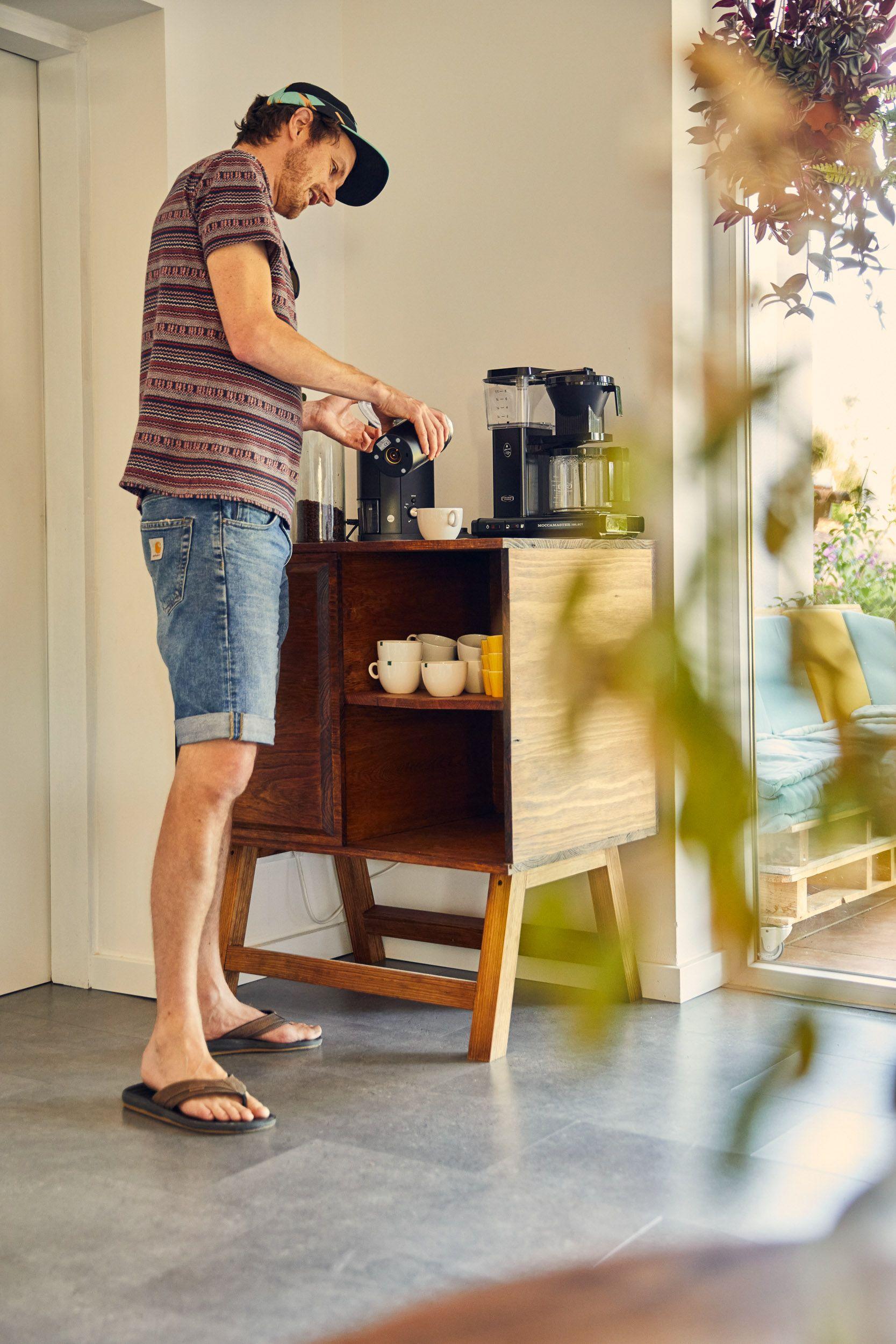 A guest using the coffee machine at the coffee corner in the shared kitchen area