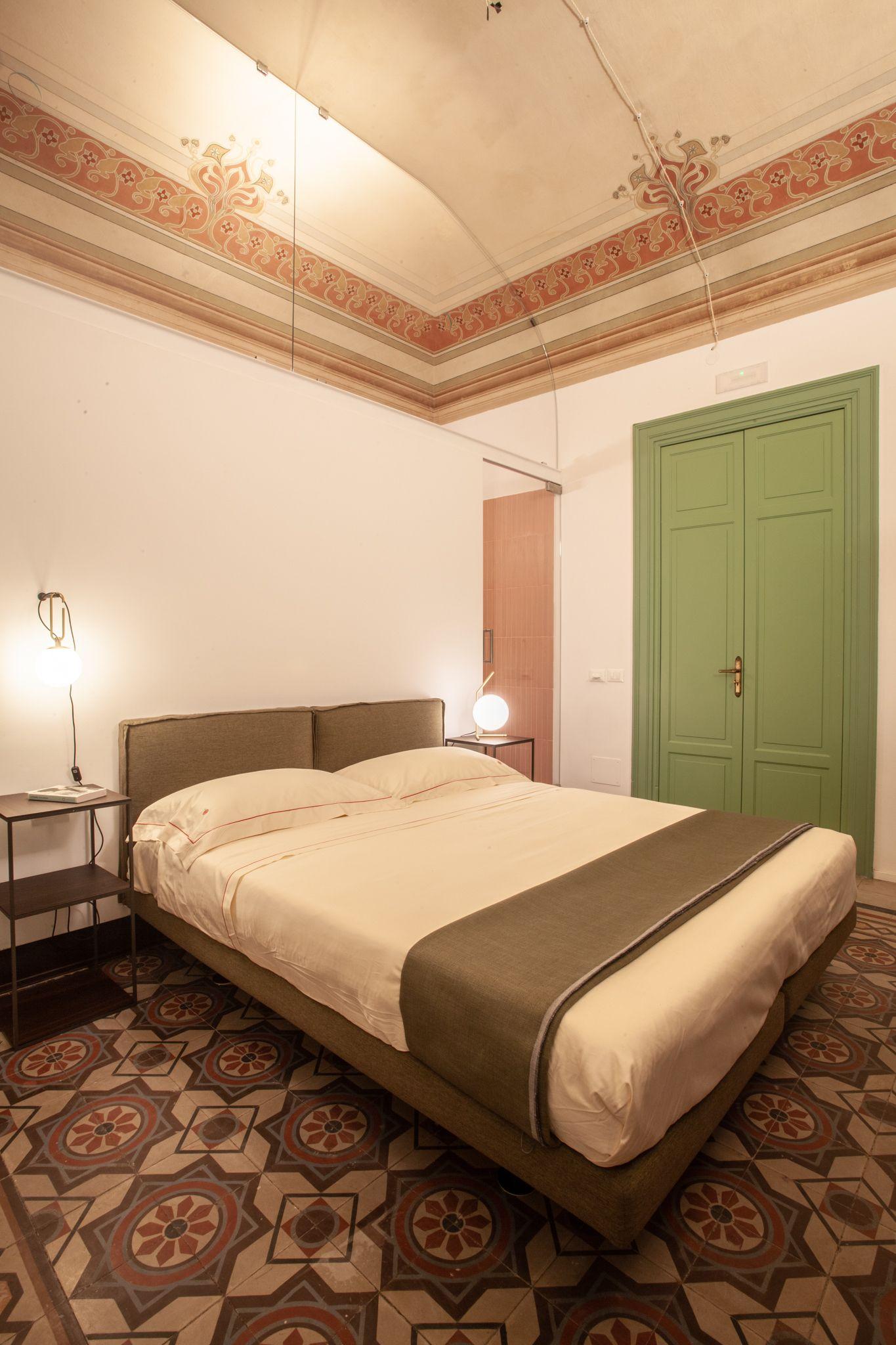 Deluxe Room 2 double bedroom with maroon sofa bed and frescoed ceiling