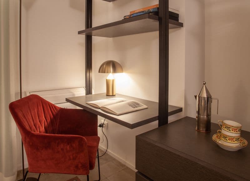 Desk nook with armchair, shelving, and coffee set in Deluxe Room 1