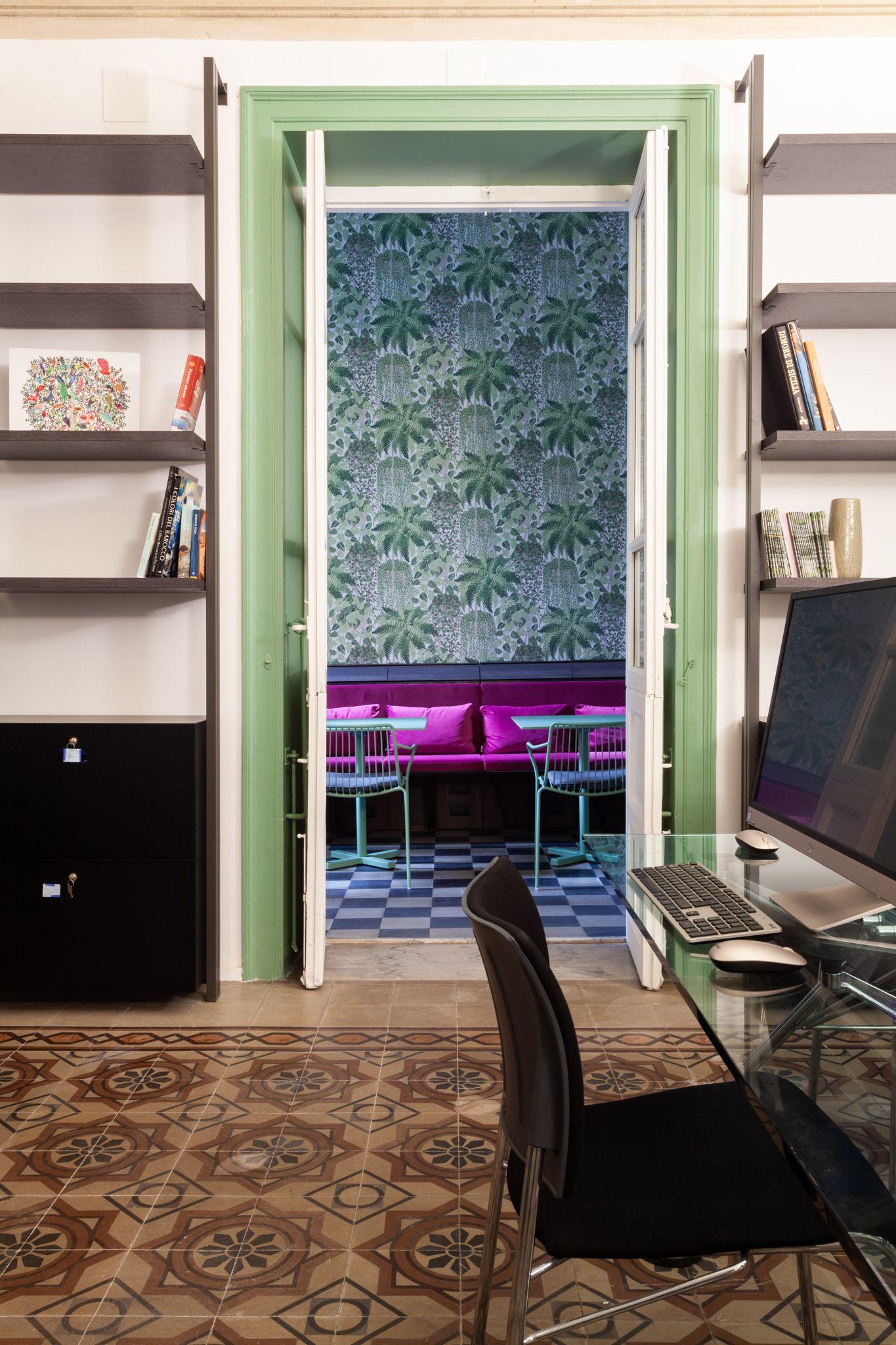 Home office nook with bookshelves, desk lamp, and view to relaxation area