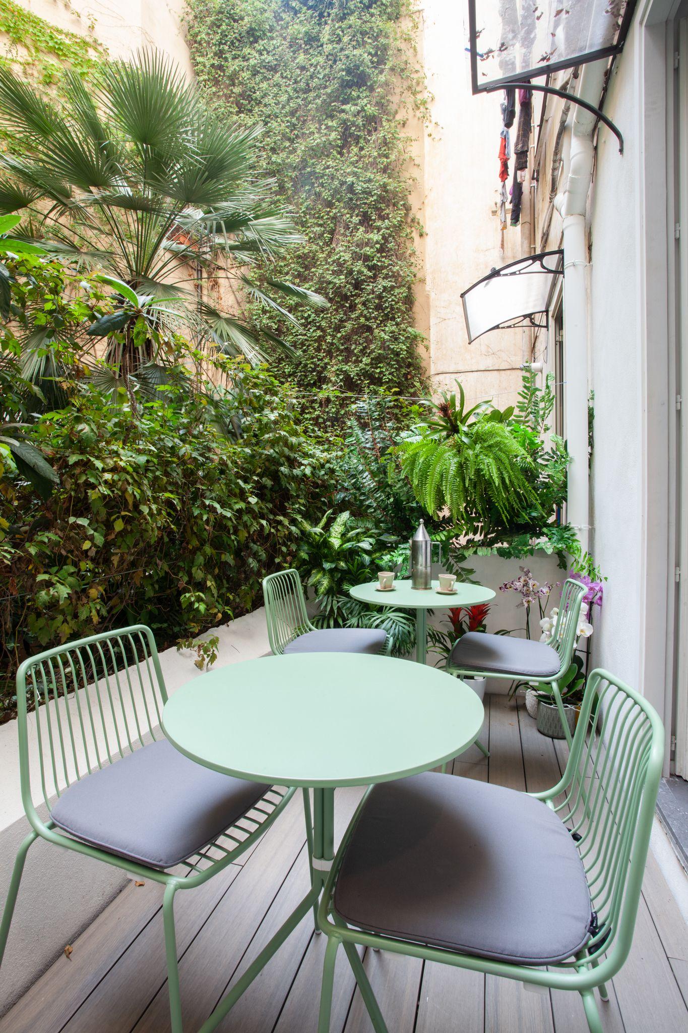 Outdoor garden terrace with green chairs and lush plants at BeetCommunity Agrigento