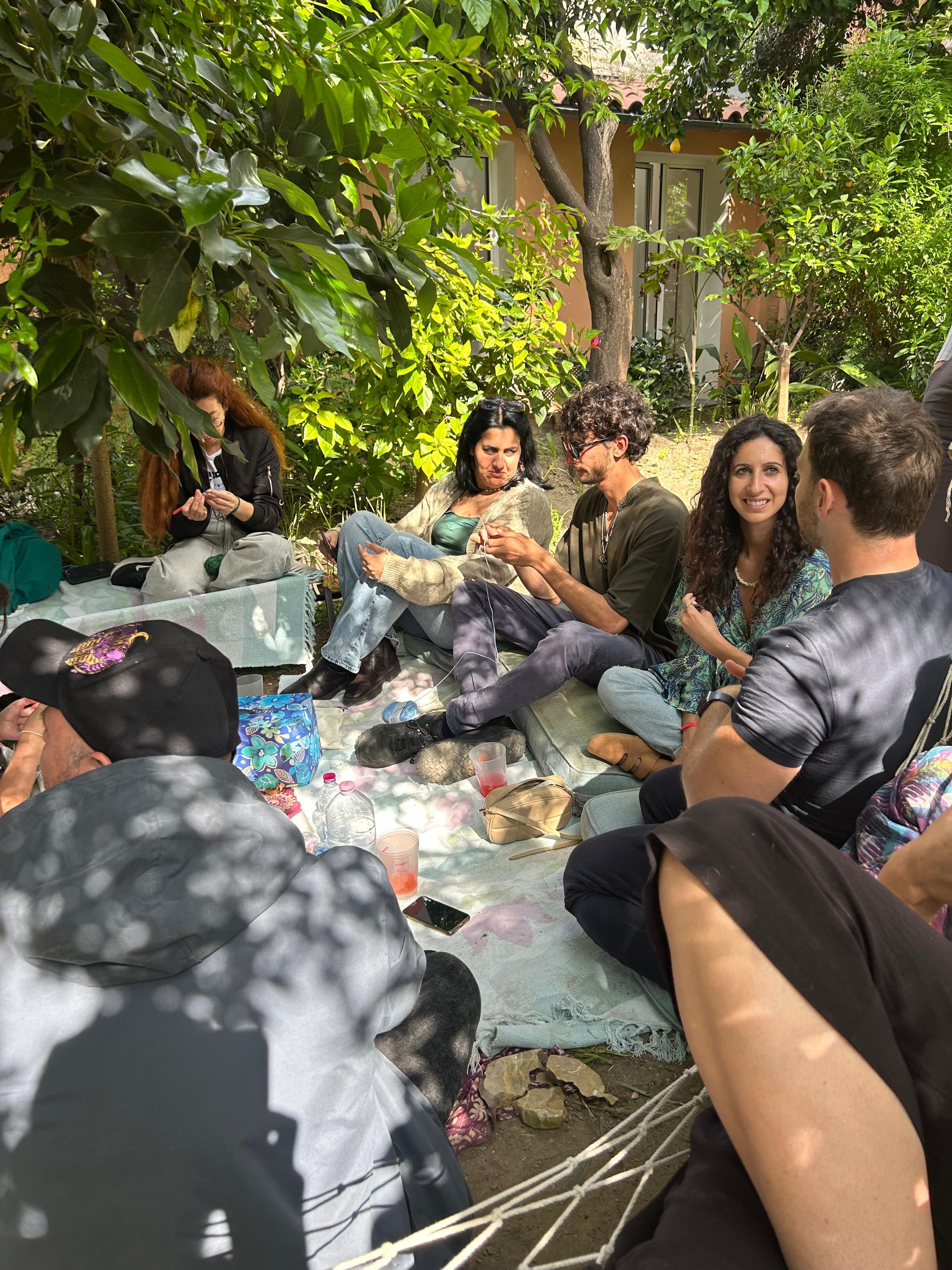 Community members gathered for a picnic under trees in a garden