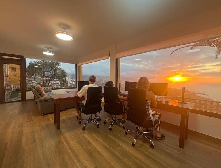 Colivers sitting in the coworking space with views of the ocean at sunset