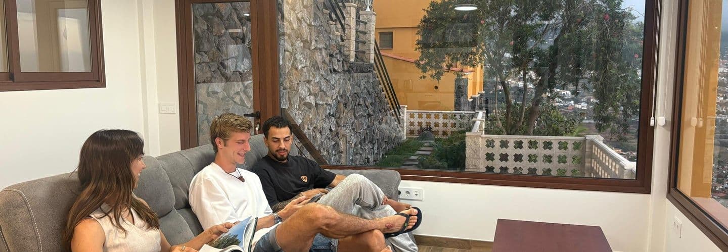 Colivers relaxing on a sofa in the chill-out lounge area with large windows overlooking the garden