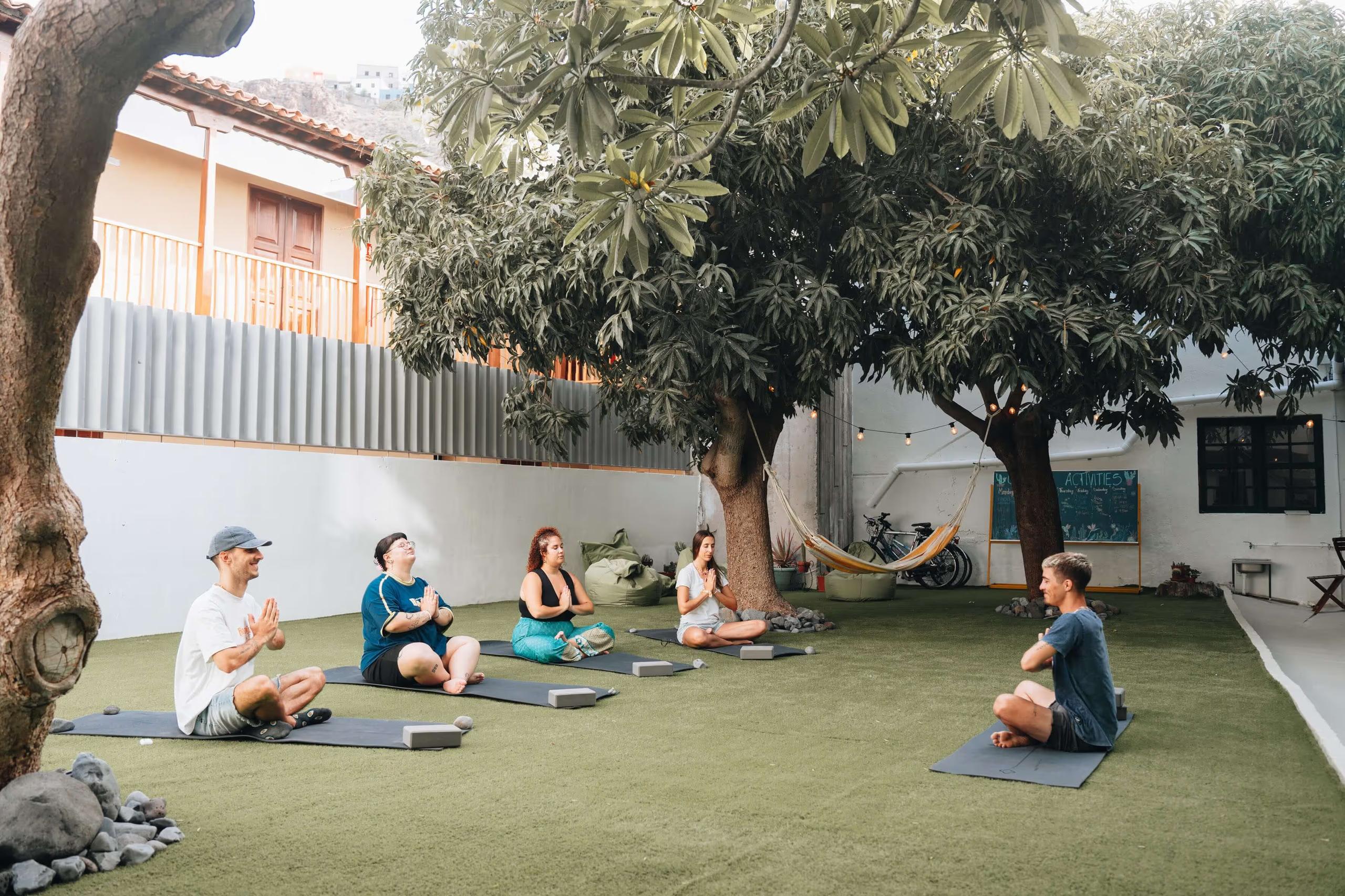Group yoga session in the garden patio under the mango trees at Cactus La Gomera