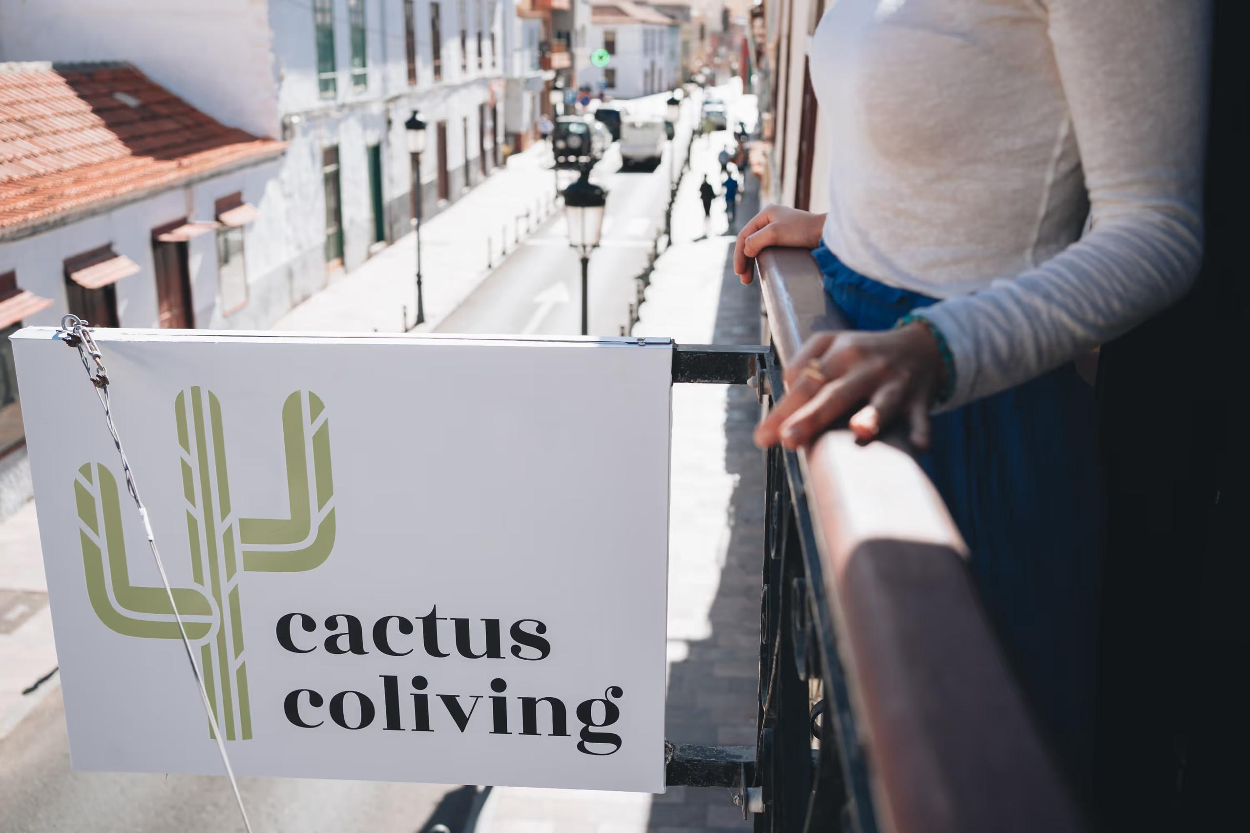 Cactus Coliving sign on the balcony with the street of San Sebastián de La Gomera visible below