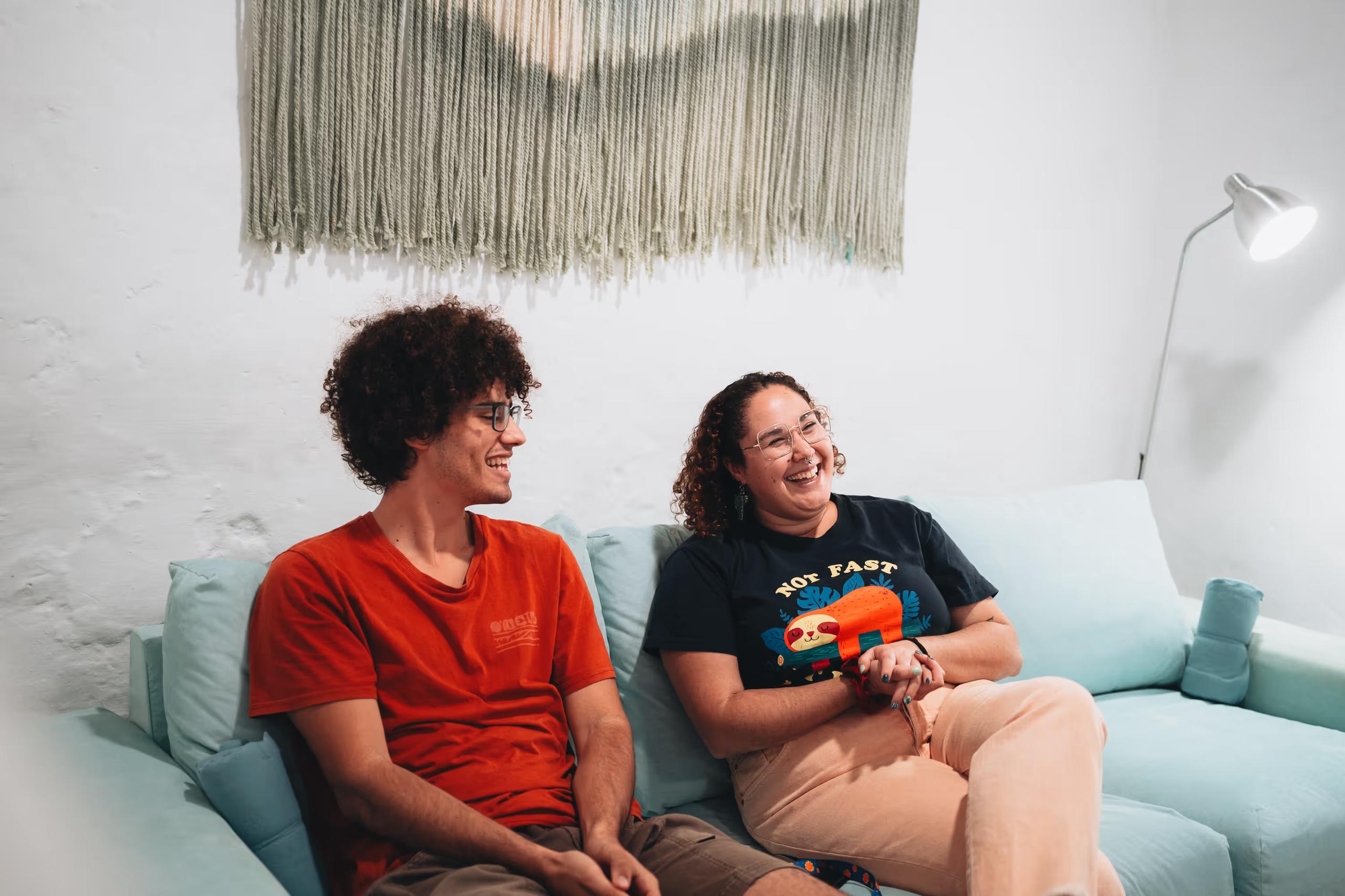 Two colivers laughing and relaxing on the sofa in the living room at Cactus La Gomera