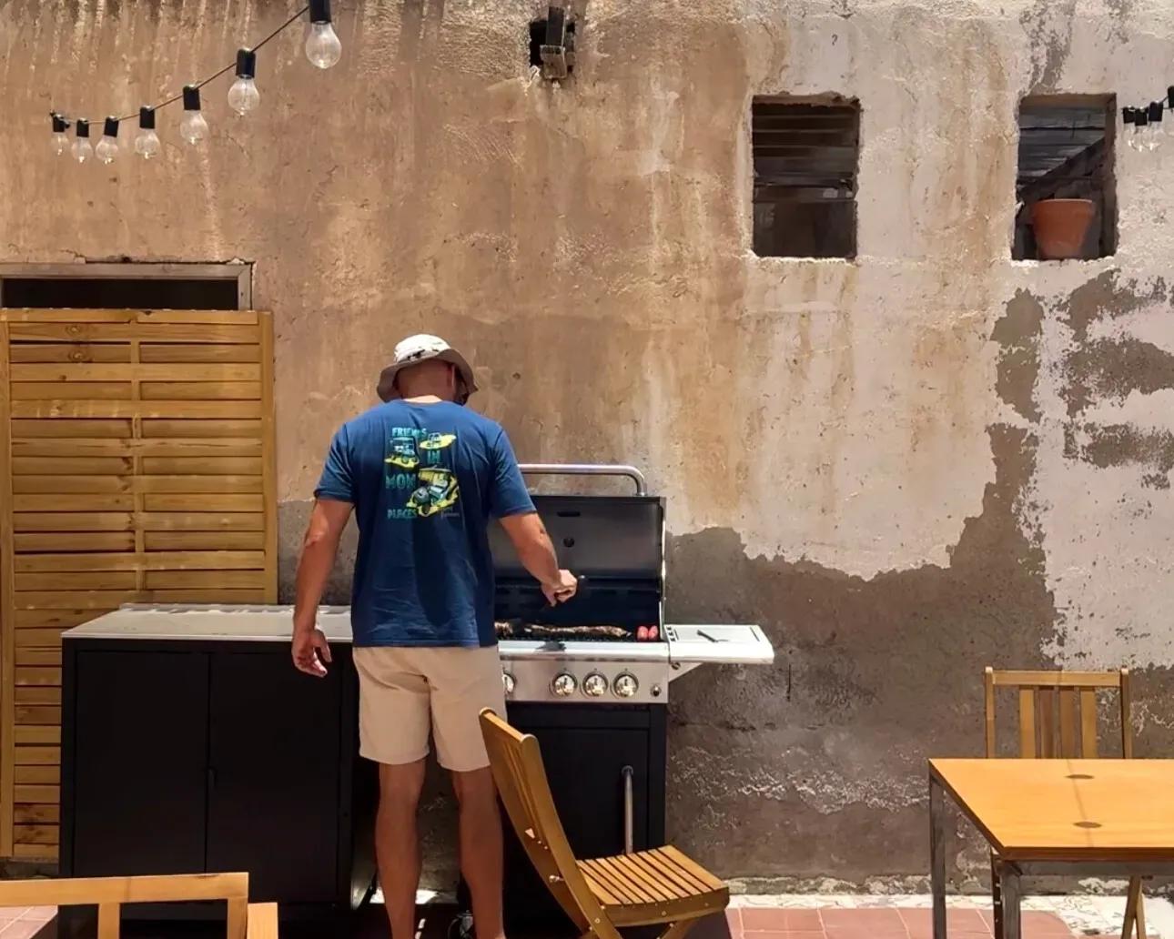 Person using the outdoor BBQ grill in the patio area