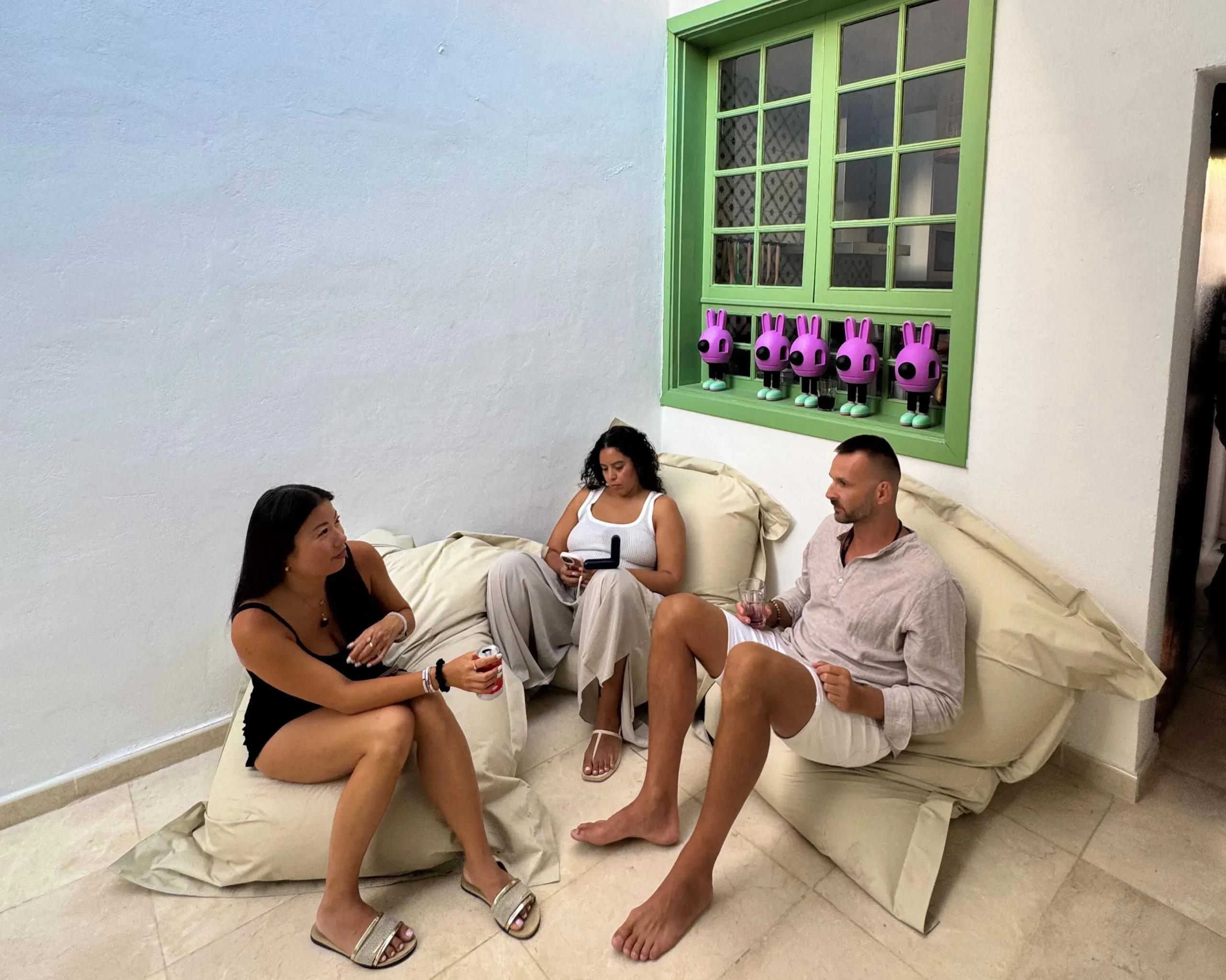 Three colivers relaxing on bean bags and floor cushions in the living room area