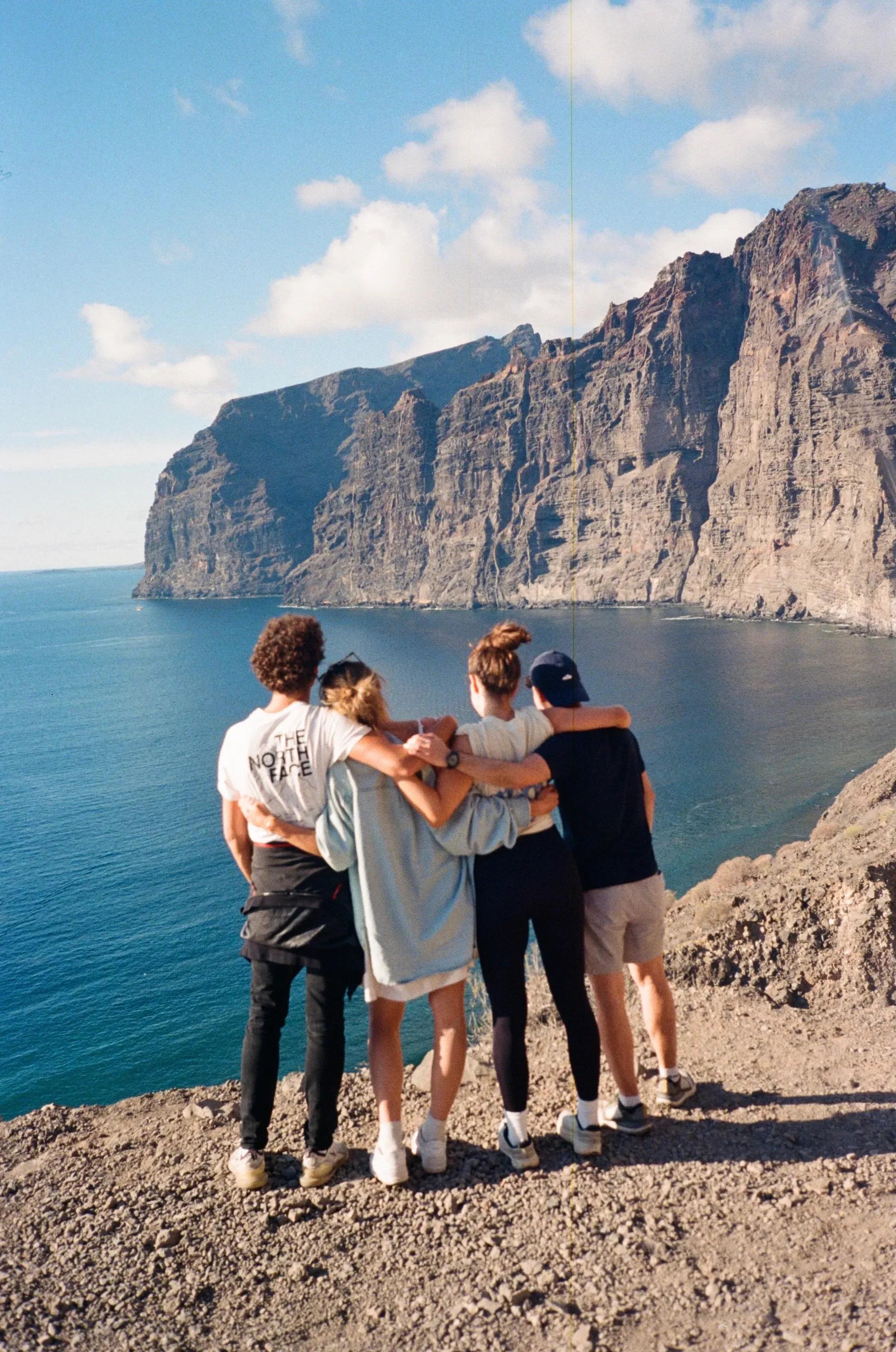 Group of colivers posing for a photo on a volcanic landscape hike with Mount Teide in the background