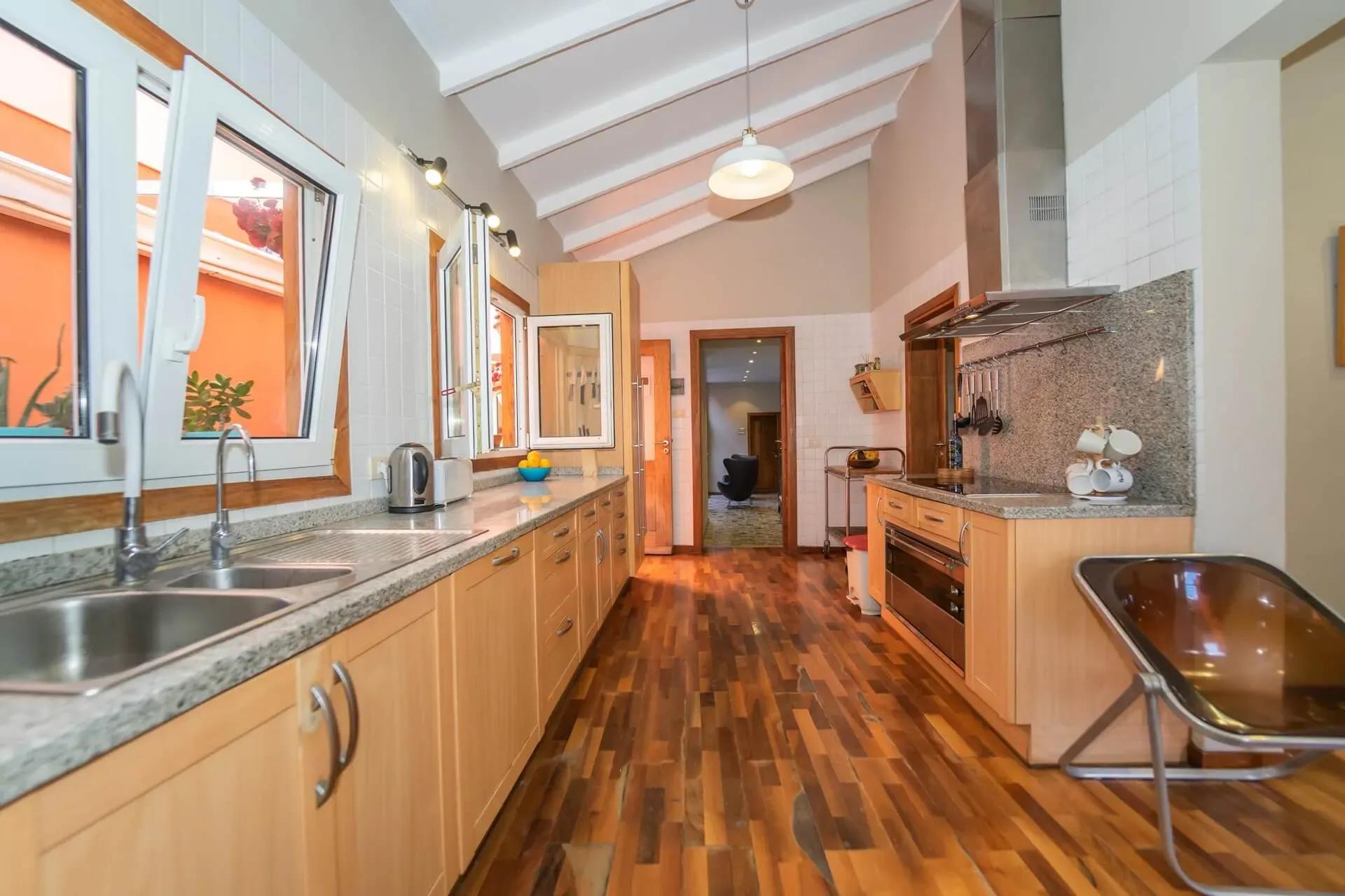 Shared kitchen with wooden cabinets, granite countertops, and wooden floor