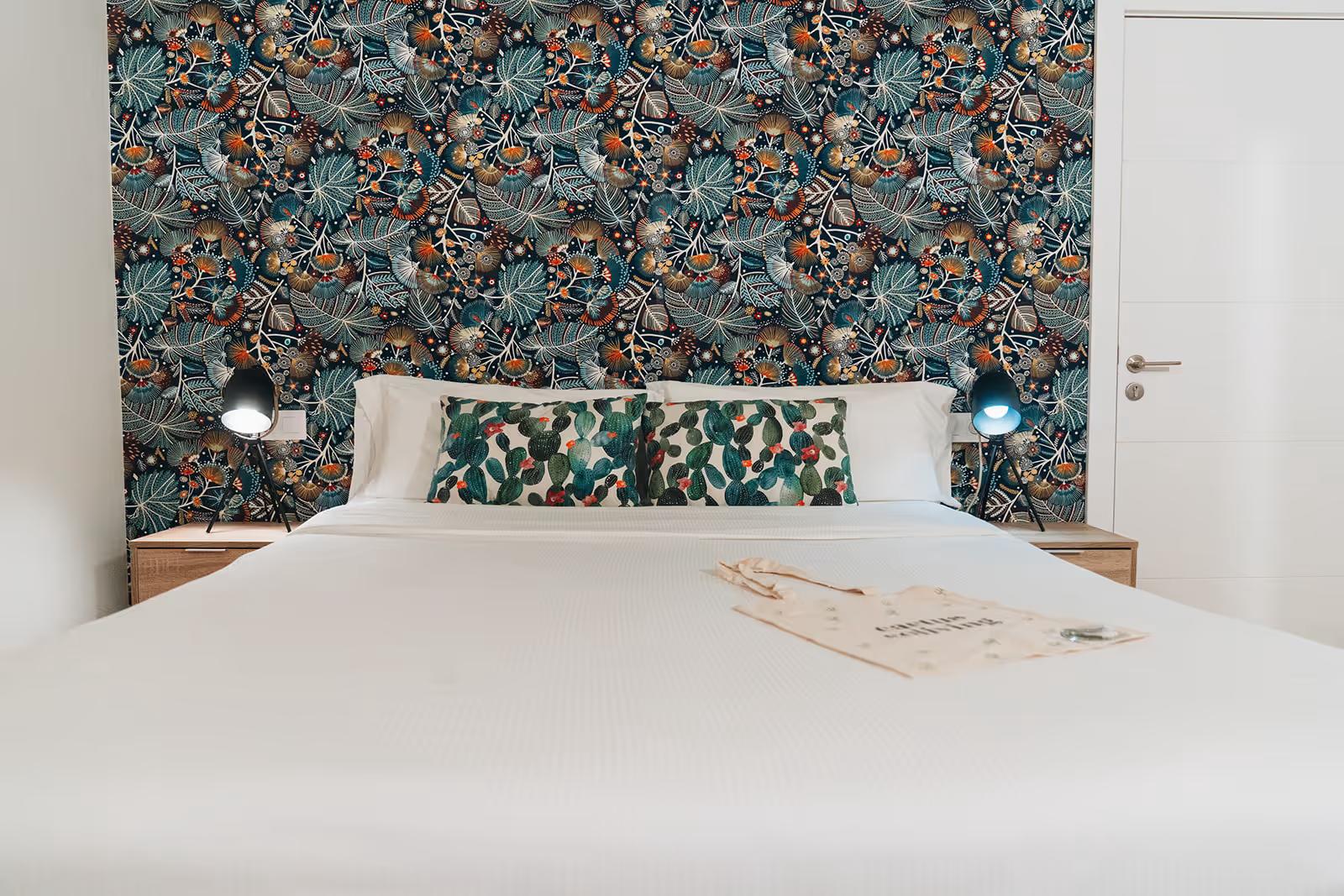 Premium double room with botanical wallpaper feature wall and cactus-print pillows, front view