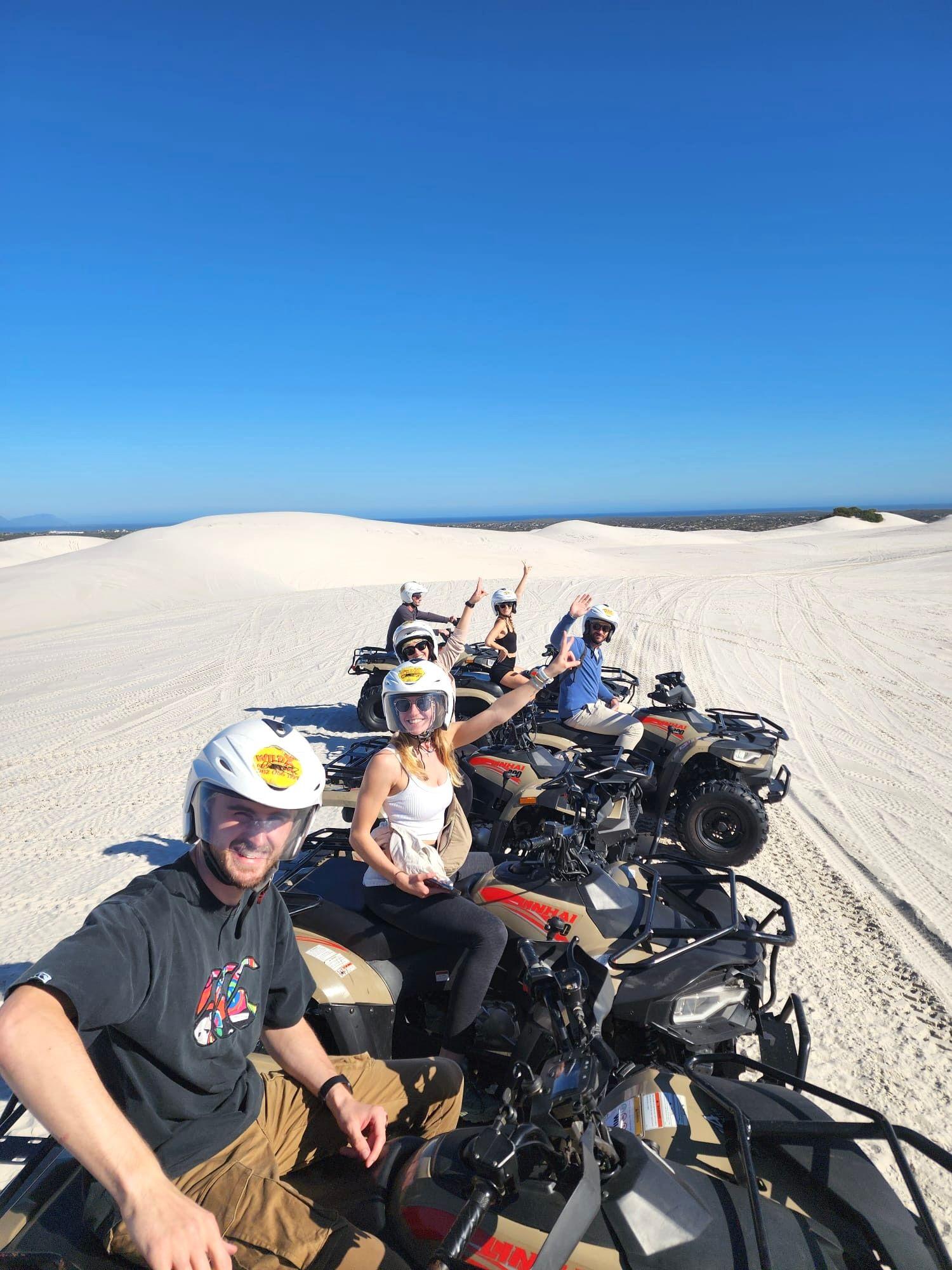Group of residents quad biking on the white sand dunes at Atlantis Dunes