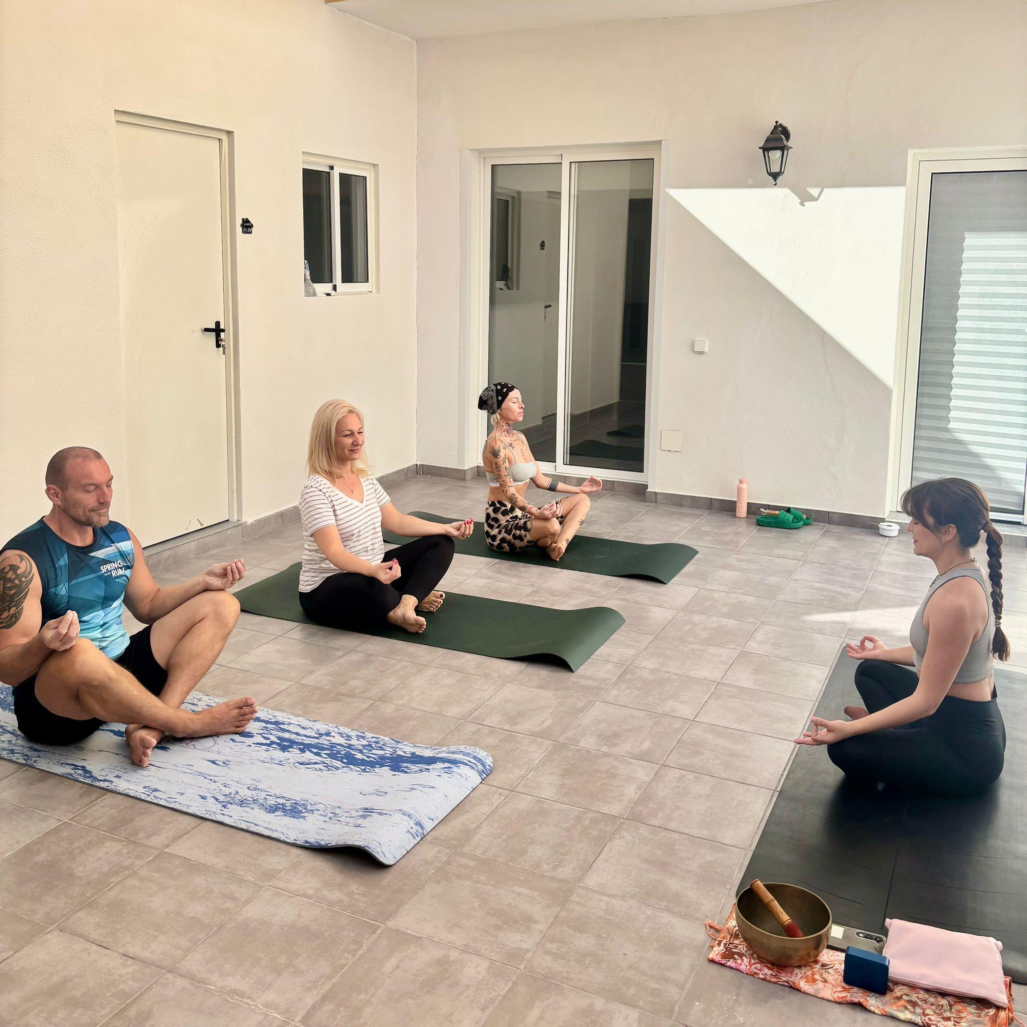 Group of digital nomads doing a yoga/meditation session indoors at Casa Capitán