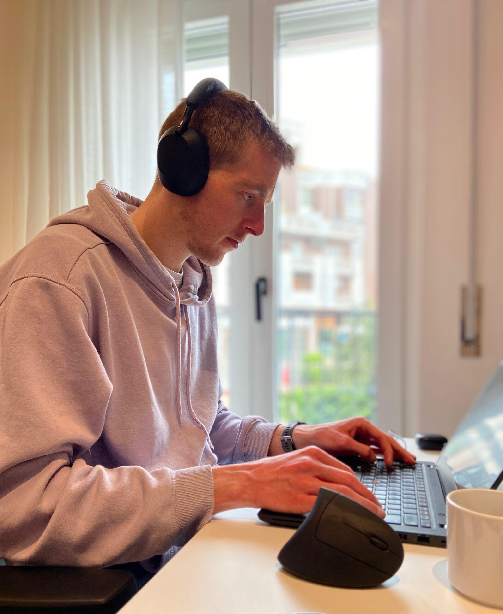 Digital nomad Jonas from Germany working on a laptop with headphones at Casa Netural coliving