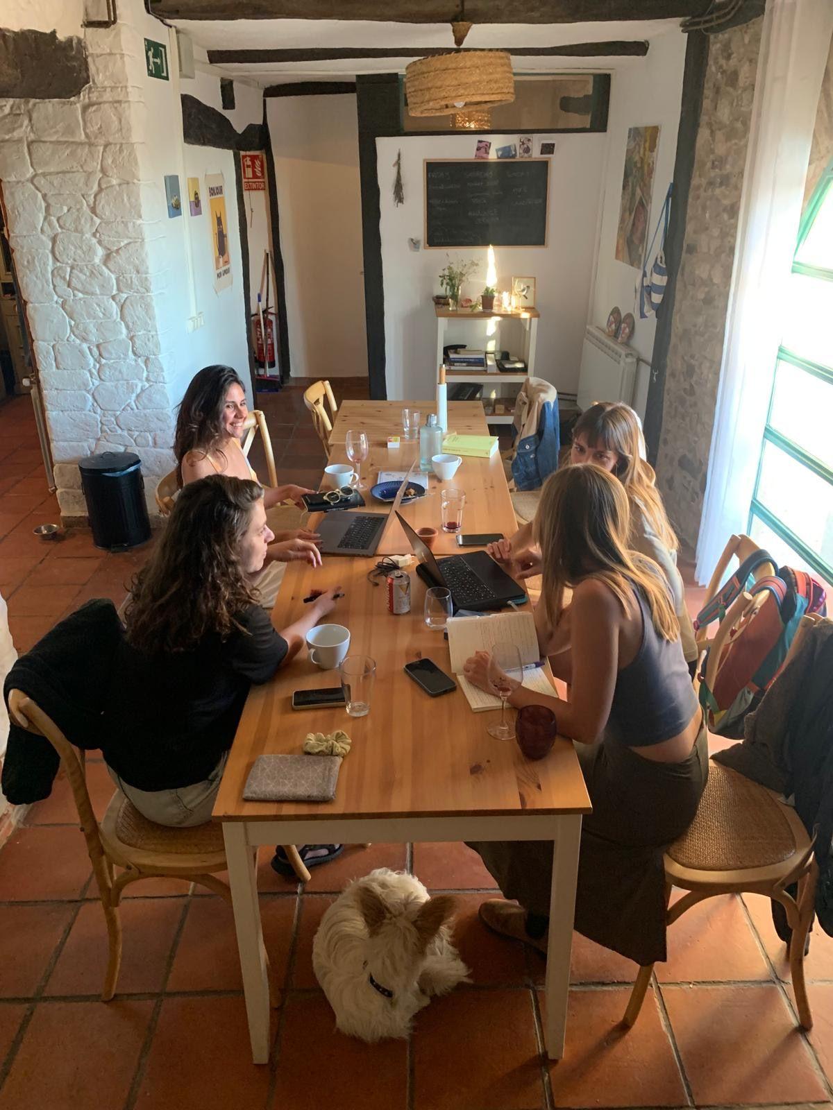 Group of people working on laptops around the coworking table in the shared space