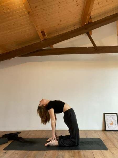 A person practicing yoga in the light-filled yoga and arts room at Casa Pardal