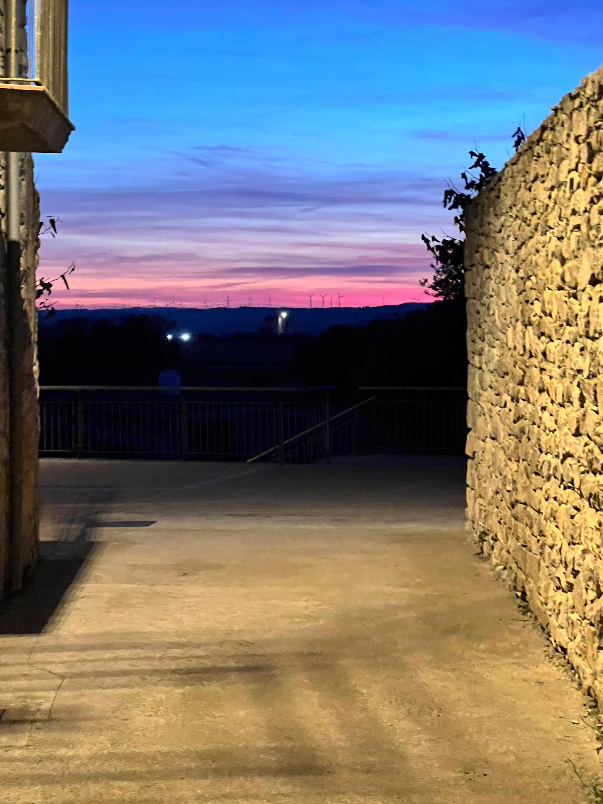 Evening sky with deep blue and pink sunset colors framed by Casa Pardal's stone walls