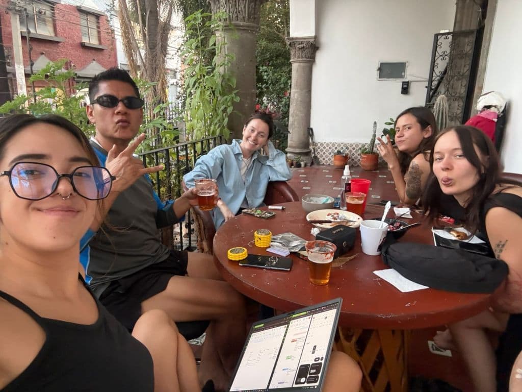 Group of coliving residents gathered on the front terrace, socializing with drinks