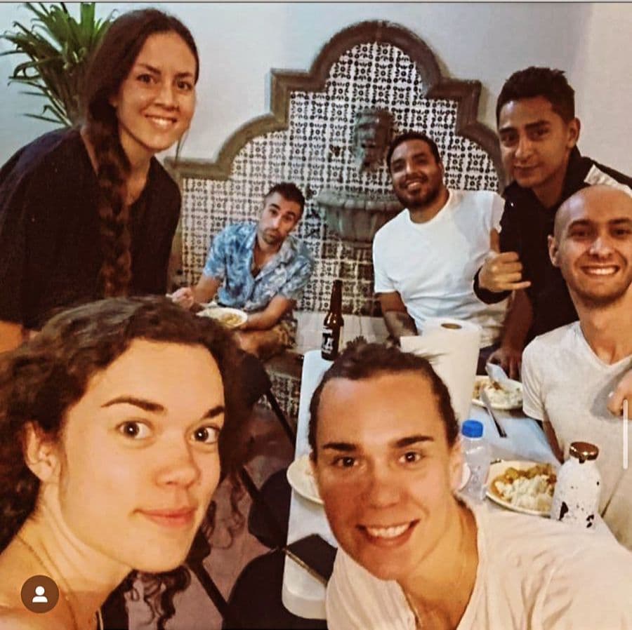 Group of coliving residents sharing a meal together, taking a selfie at the dining table
