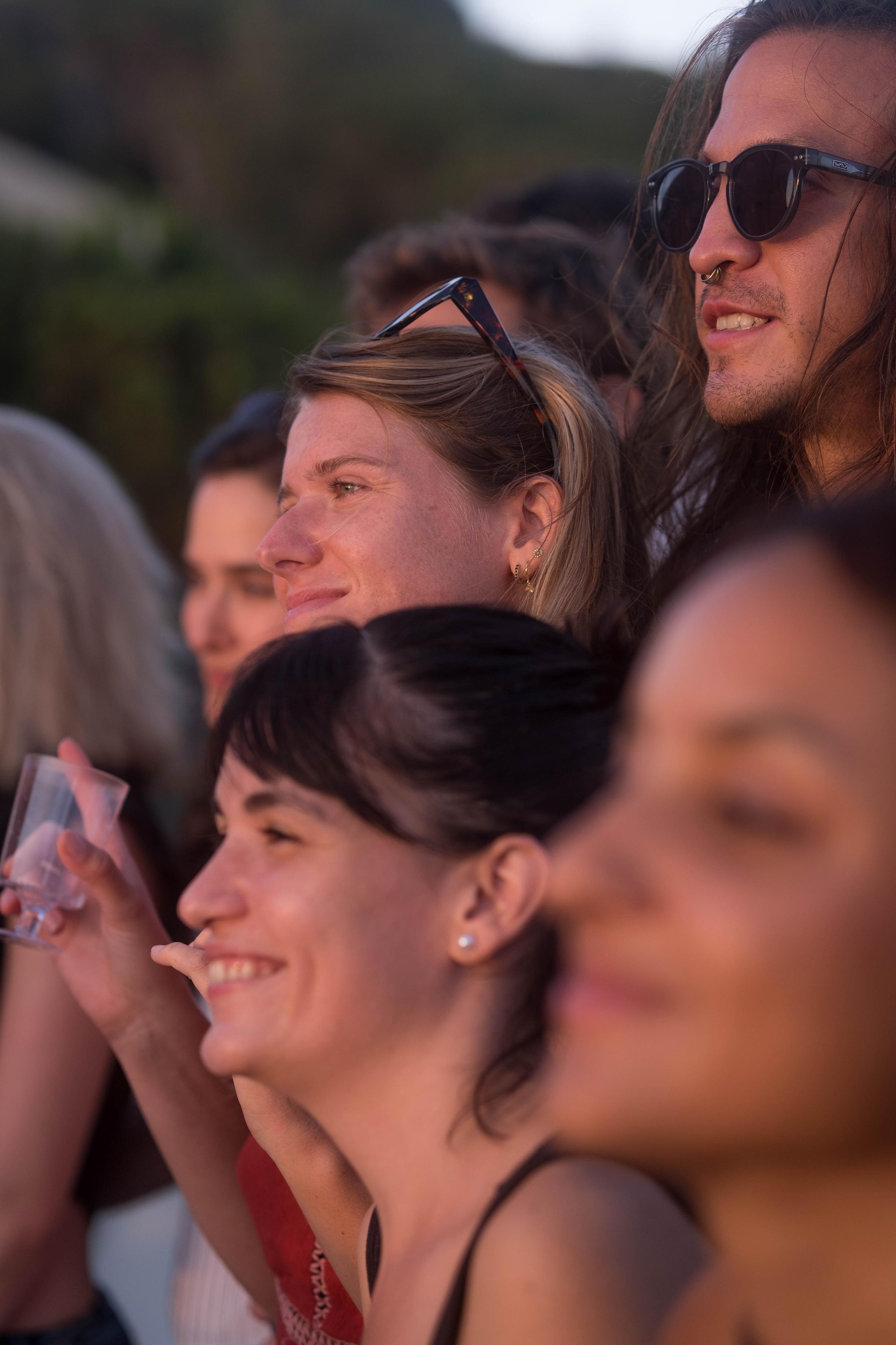 Group of community members gathered together at an outdoor event, smiling and socialising.