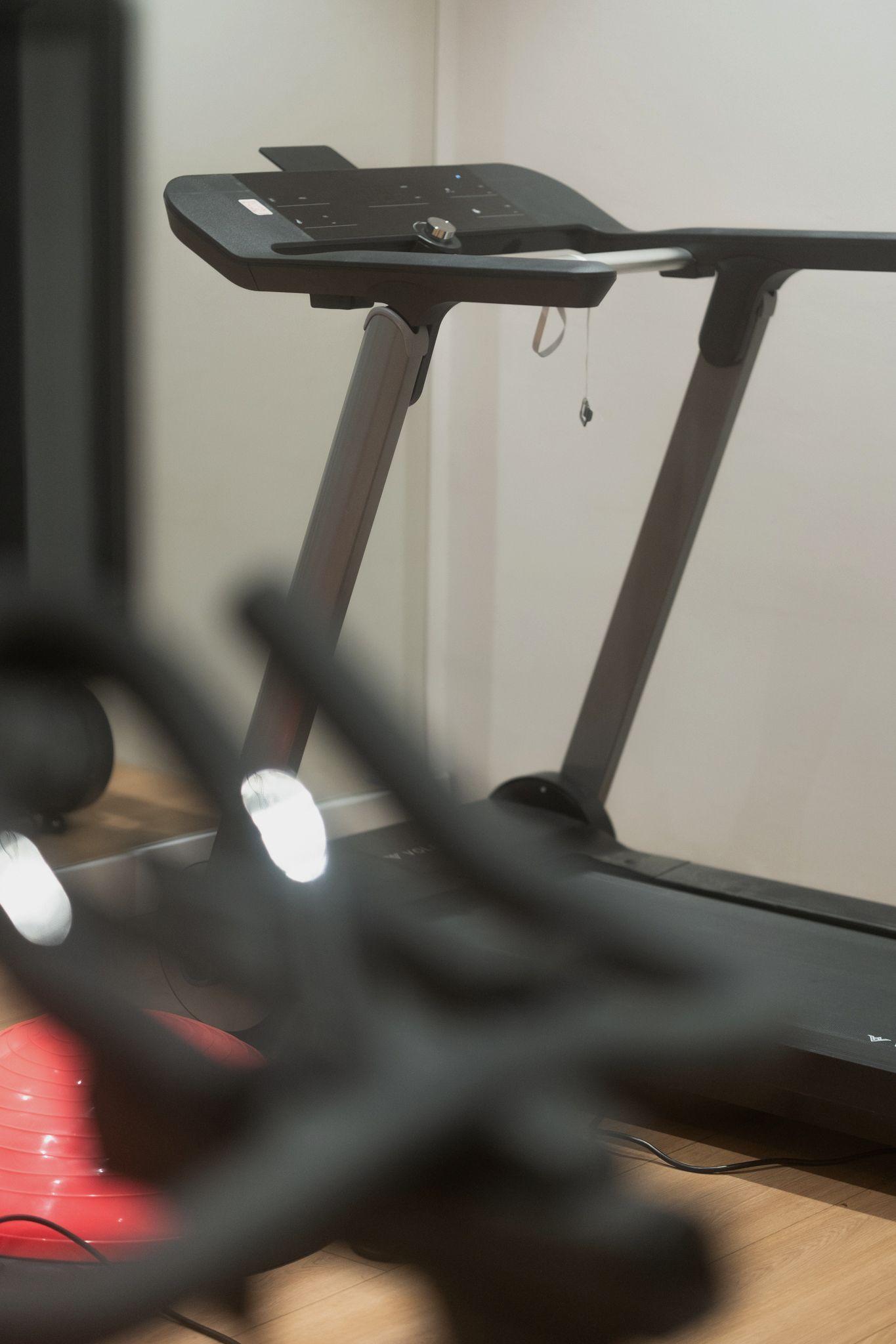 A private cabin or booth for focused work, with a glass door, a small desk, a lamp, and a single chair.