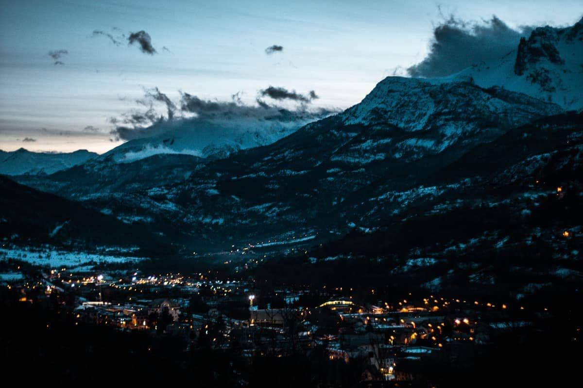 Night view of Briançon valley with city lights and snow-capped mountains