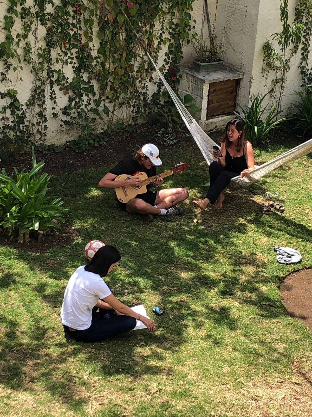 Community members relaxing in the garden with a guitar and hammock