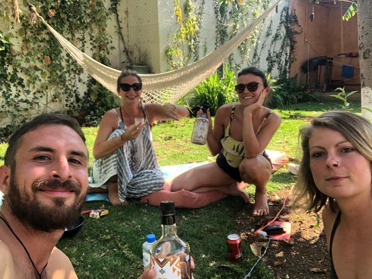 Community members relaxing on the grass with drinks and a hammock in the garden