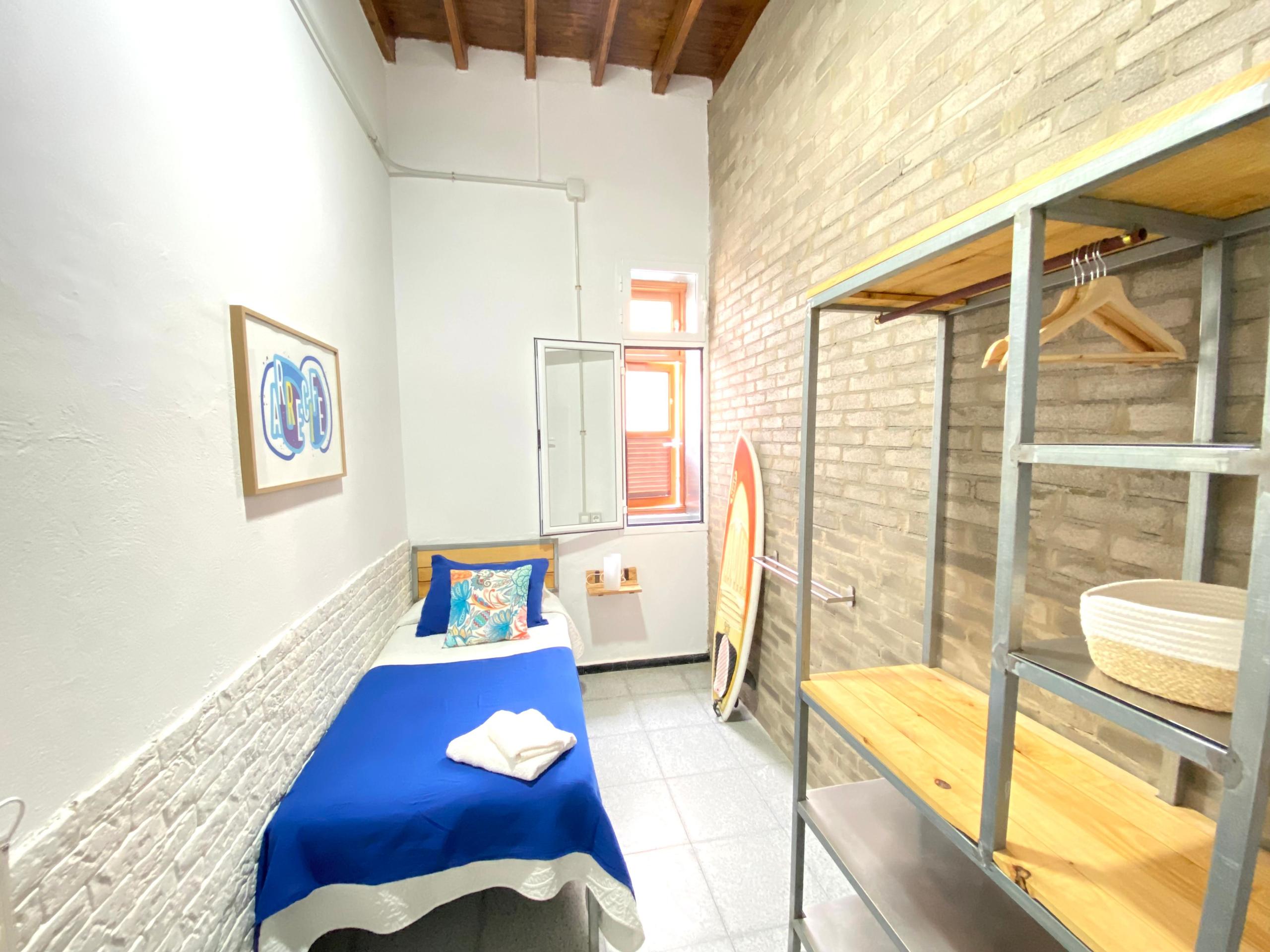 Single room in EcoIsleta Coliving, with one bed and a desk inside of the room to work remotely.