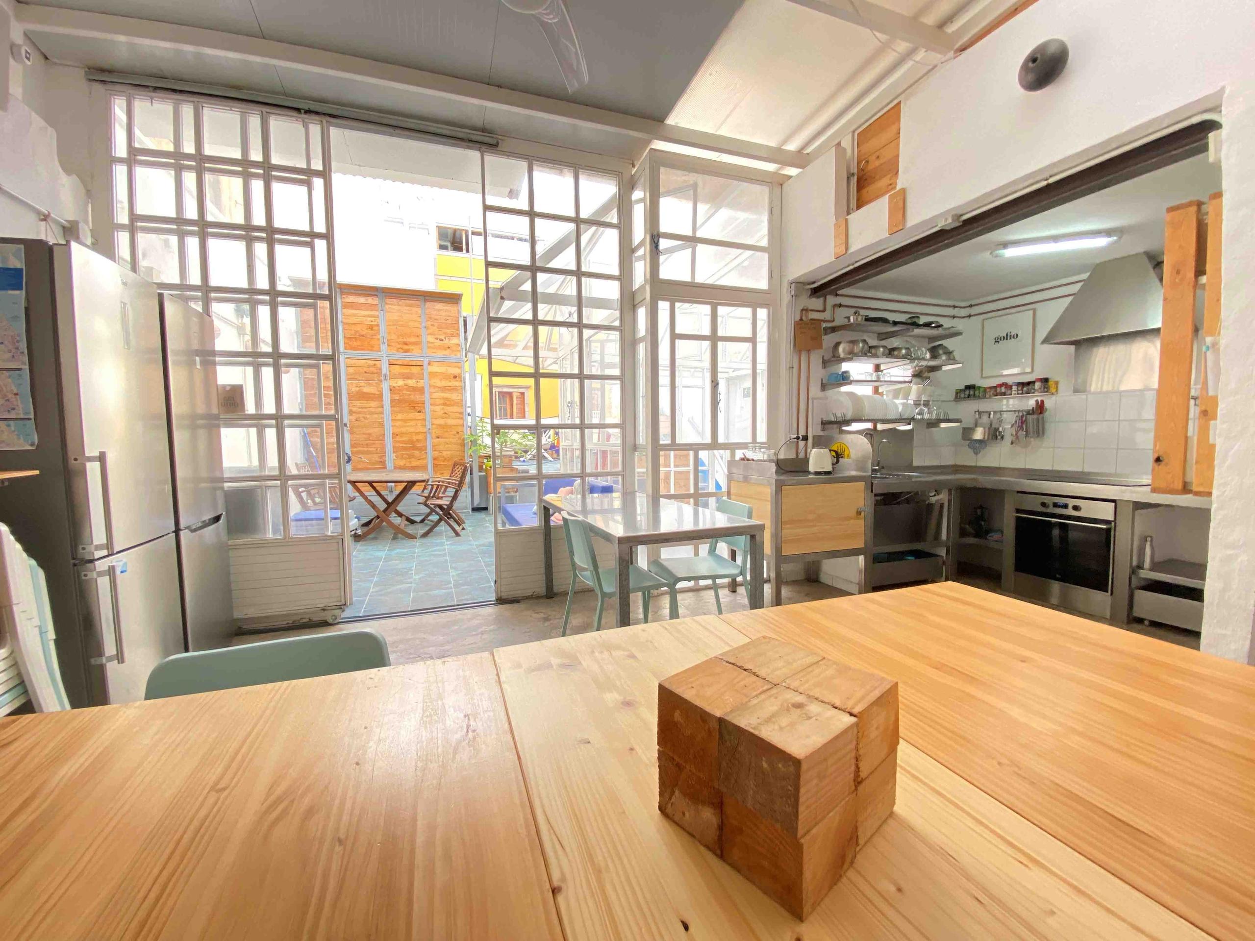 Coworking area and view of the terrace in EcoIsleta Coliving in Gran Canaria, desk to work remotely and view of the kitchen