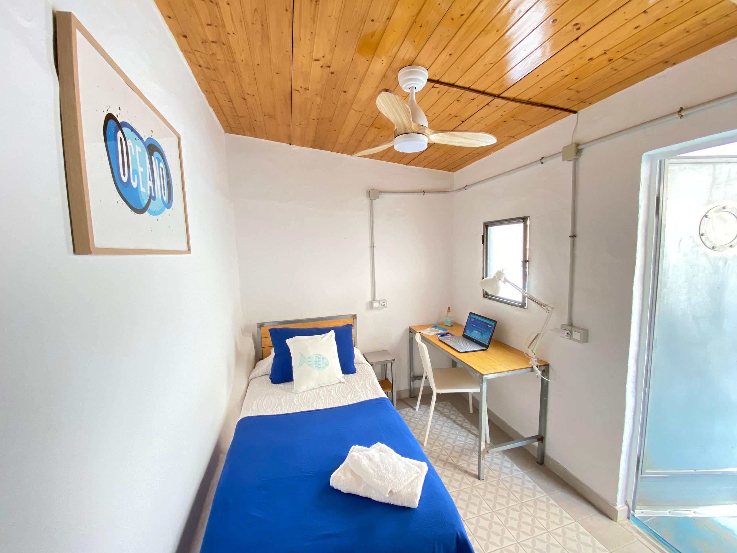Single Ensuite Room in a Coliving Las Palmas, with desk, ceiling fan, single bed and toilet with shower, ideal for remote workers and artists